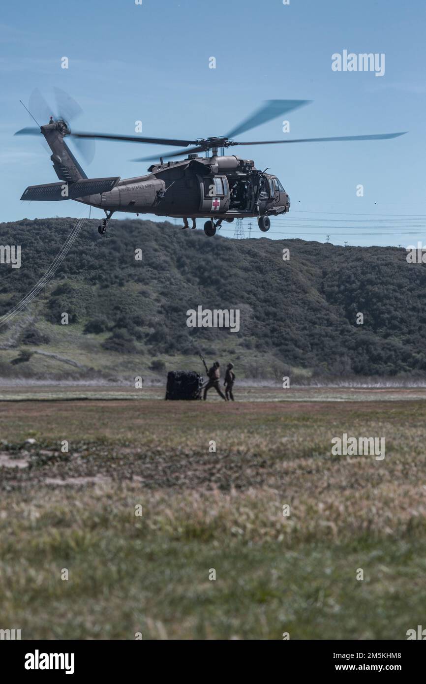 USA Marines mit 1. Landungsbataillon, Kampflogistikbataillon 1, 1. Marine Logistics Group, bereiten sich darauf vor, eine Ladung Reifen an eine US-amerikanische anzuhängen Army UH-60 Black Hawk, zugewiesen zur Golffirma, 7. Bataillon, 158. Luftfahrtregiment, während eines Helicopter Support Team Trainingsereignisses in Camp Pendleton, Kalifornien, 22. März 2022. Marines und Soldaten führten diese Schulung durch, um die Logistikkenntnisse zu verbessern und die Fähigkeit zur Ausführung potenzieller Notfallmissionen und zur Interoperabilität zu verbessern. Stockfoto