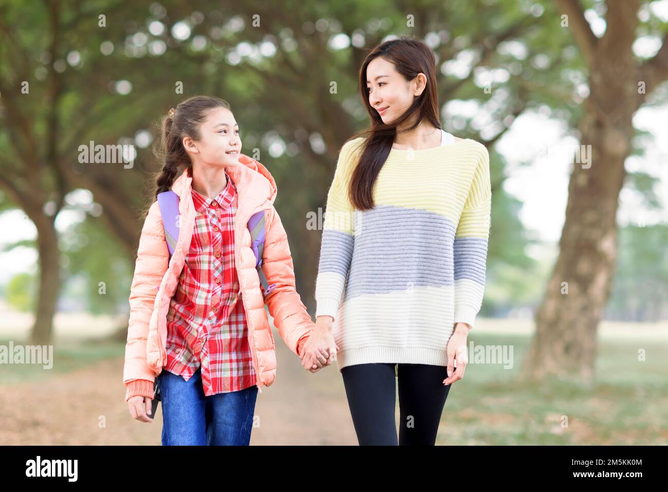 Glückliches Mädchen geht mit ihrer Mutter zur Schule Stockfoto