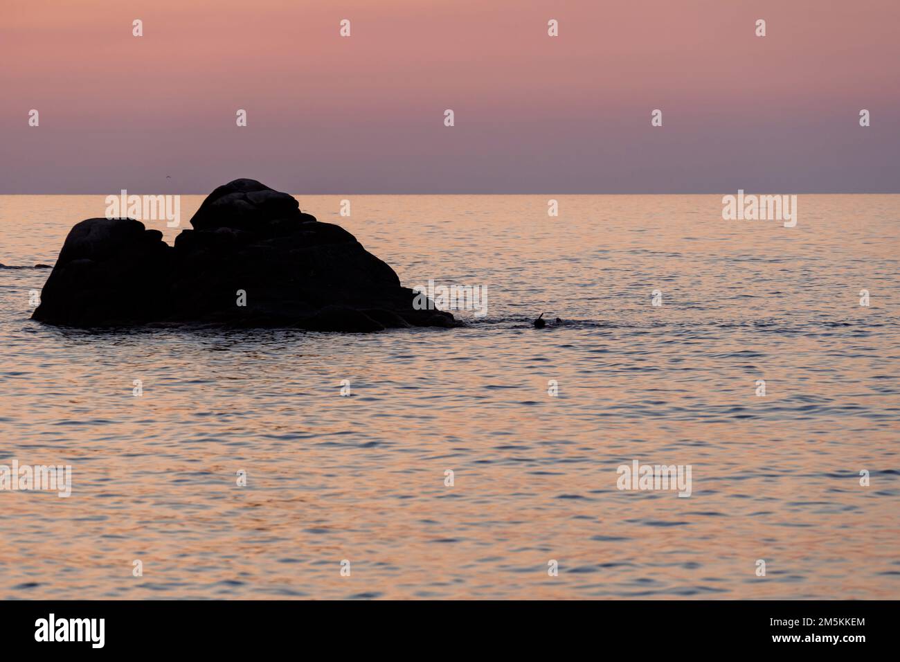 Tropische, farbenfrohe Landschaft bei Sonnenaufgang. Naturlandschaft. Tropische Inselküste. Wunderschöne Aussicht auf die orangefarbene Sonnenuntergangslandschaft mit Felsen Stockfoto