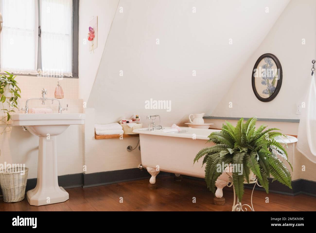 Weißes Sockelwaschbecken und rollstuhlgerechte Badewanne im Hauptschlafzimmer im Obergeschoss im rekonstruierten Blockhaus aus den 1840er Jahren. Stockfoto