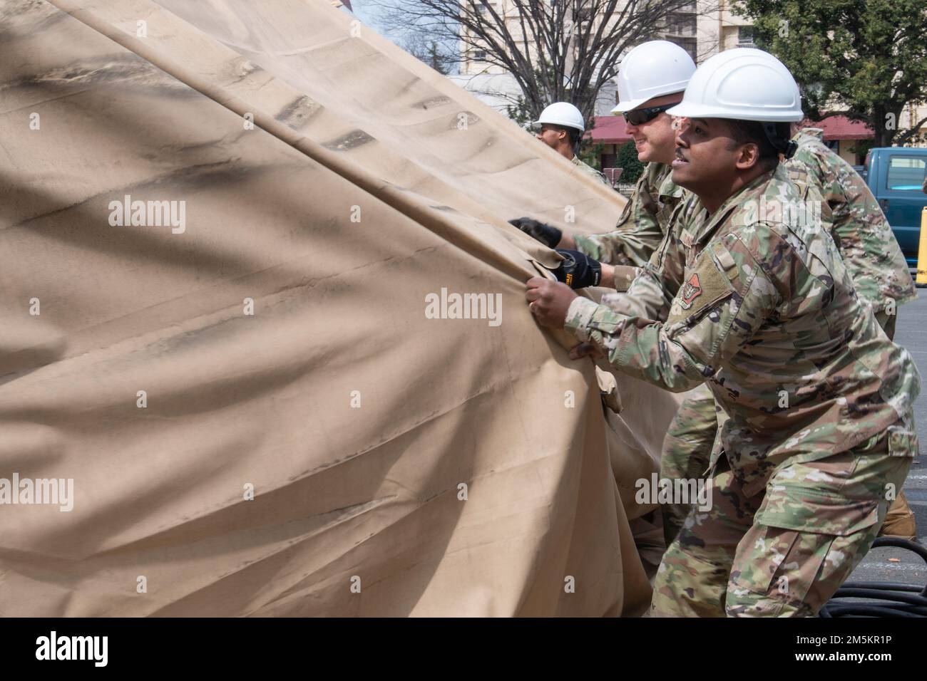 Chief Master Sgt. Jerry Dunn, 374. Airlift Wing Kommandochef, hilft beim Abriss des ehemaligen COVID-19 Test Zelt Regenschutz während des Abbaus am Yokota Air Base, Japan, 23. März 2022. Durch die Entfernung des Zelts wird mehr Platz für Patienten am Basiskrankenhaus zur Verfügung stehen, und es wird eine komfortablere und effizientere Versorgung innerhalb der Einrichtung ermöglicht. Stockfoto