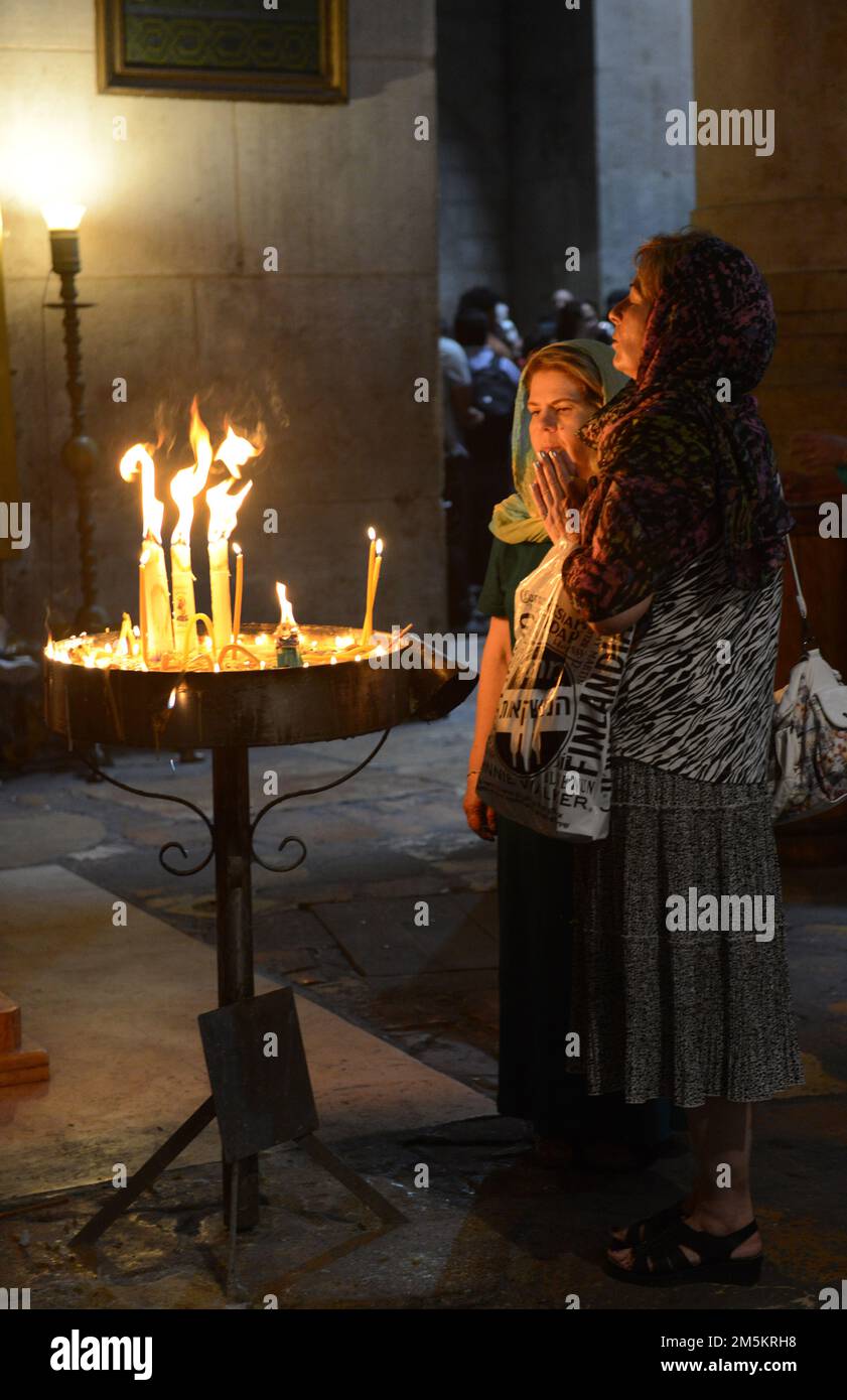 Frauen zünden Kerzen in der Kirche des heiligen Grabes in der Altstadt von Jerusalem, Israel. Stockfoto