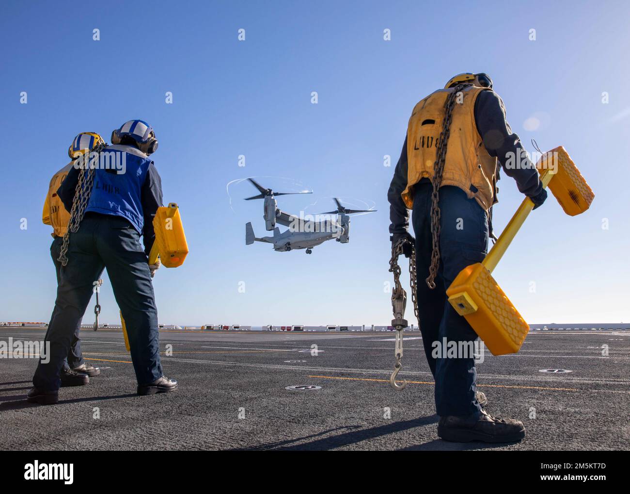220323-N-IV962-1057 PAZIFIK (23. März 2022) – Seeleute bereiten sich darauf vor, einen MV-22 Osprey zu blockieren und zu ketten, der der Marine Medium Tiltrotor Squadron (VMM) 362 an Bord des Amphibienschiffs USS Makin Island (LHD 8), März 23. Makin Island führt Routineeinsätze in der US-3.-Flotte durch. Stockfoto