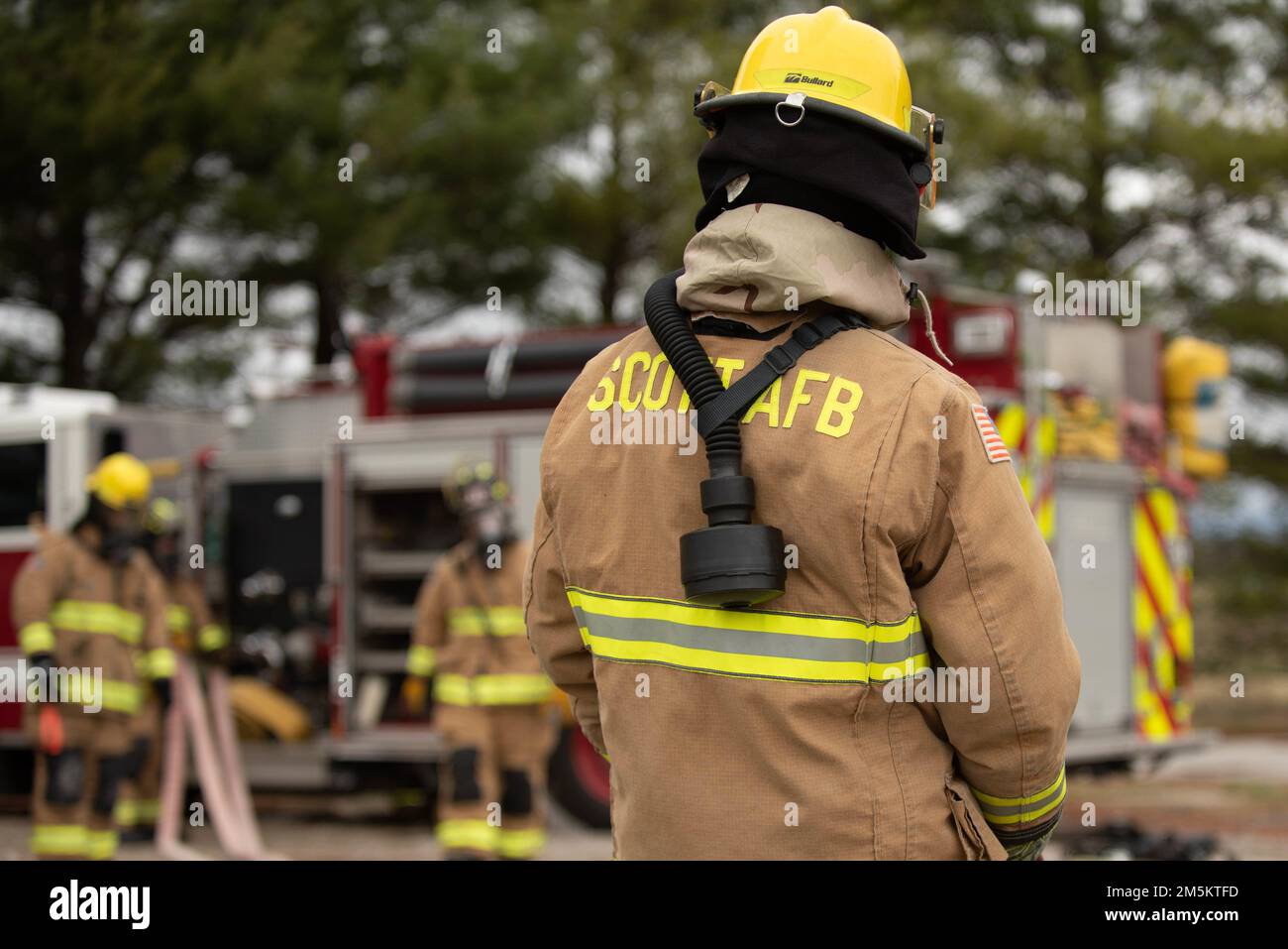 Ein Feuerwehrmann aus dem 375. Bauingenieur-Geschwader hilft beim Rollen eines Schlauchs, nachdem er während einer Einsatzprobe auf dem Luftwaffenstützpunkt Scott, Illinois, am 23. März 2022 einen simulierten Brand auslöschte. Bei dieser Mobilitätsprüfung für den Einsatz werden die Einsatzbereitschaft der Führungs- und Kontrollverfahren und die Kontinuität des Betriebs in einem simulierten umstrittenen Umfeld hervorgehoben. Stockfoto