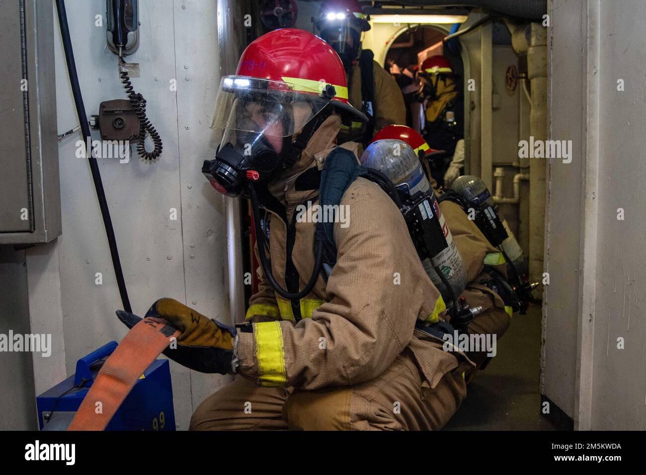 220323-N-WU964-1023 YOKOSUKA, Japan (23. März 2022) Seeleute simulieren die Brandbekämpfung während einer Übung zur Schadensbegrenzung an Bord der USA Der einzige vorwärtsgesetzte Flugzeugträger der Navy USS Ronald Reagan (CVN 76). Ronald Reagan-Matrosen üben eine Schadenskontrolle aus, um sich auf Unfälle vorzubereiten, die im Hafen auftreten können. Ronald Reagan, das Flaggschiff der Carrier Strike Group 5, stellt eine kampfbereite Truppe bereit, die die Vereinigten Staaten schützt und verteidigt und Bündnisse, Partnerschaften und kollektive maritime Interessen in der Region Indo-Pazifik unterstützt. Stockfoto