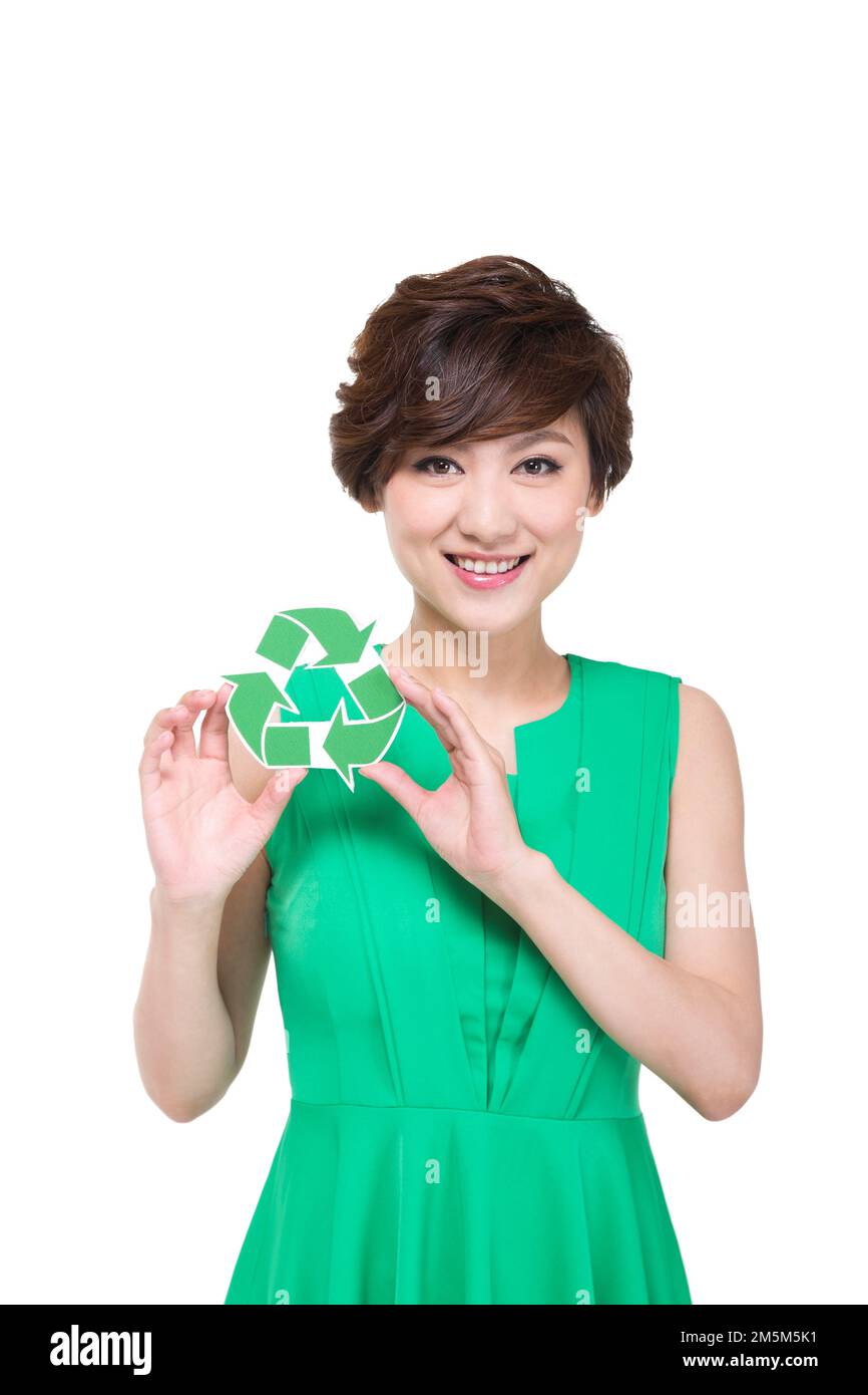 Die junge Frau im grünen Rock mit Umweltzeichen Stockfoto