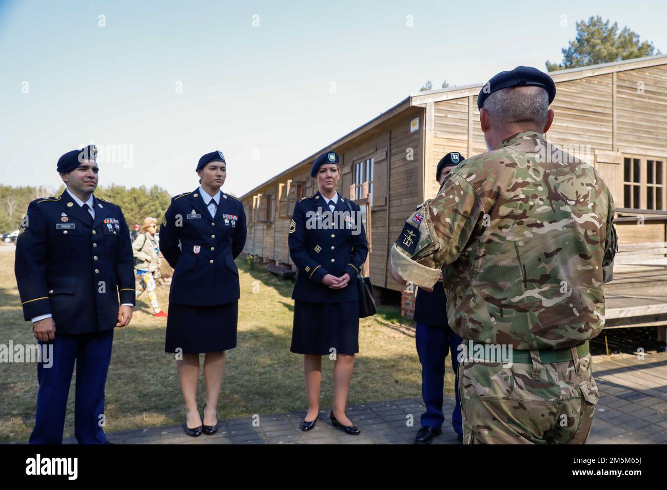 Haftbefehl-Officer Gary Edwards, der der Defence Academy of the United Kingdom in Shrivenham zugewiesen wurde, erläutert die Geschichte des Stalag Luft III in Zagan, Polen, 24. März 2022. Militärangehörige verschiedener Nationen nahmen an der Gedenkfeier der sogenannten „Großen Flucht“ Teil, einem Fluchtversuch, der von Flugzeugen der britischen Royal Air Force aus einem deutschen Kriegsgefangenenlager in Zagan während des Zweiten Weltkriegs inszeniert wurde und mit der Hinrichtung von 50 zurückgekommenen Gefangenen endete. Stockfoto