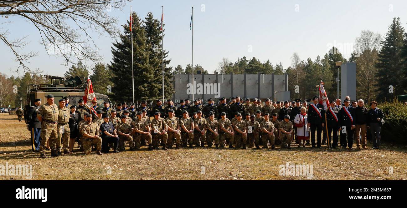 Britische, polnische und amerikanische Militärangehörige posieren während einer Gedenkveranstaltung in Zagan, Polen, am 24. März 2022 für ein Foto. Militärangehörige verschiedener Nationen nahmen an der Gedenkfeier der sogenannten „Großen Flucht“ Teil, einem Fluchtversuch, der von Flugzeugen der britischen Royal Air Force aus einem deutschen Kriegsgefangenenlager in Zagan während des Zweiten Weltkriegs organisiert wurde und mit der Hinrichtung von 50 zurückgekommenen Gefangenen endete. Stockfoto