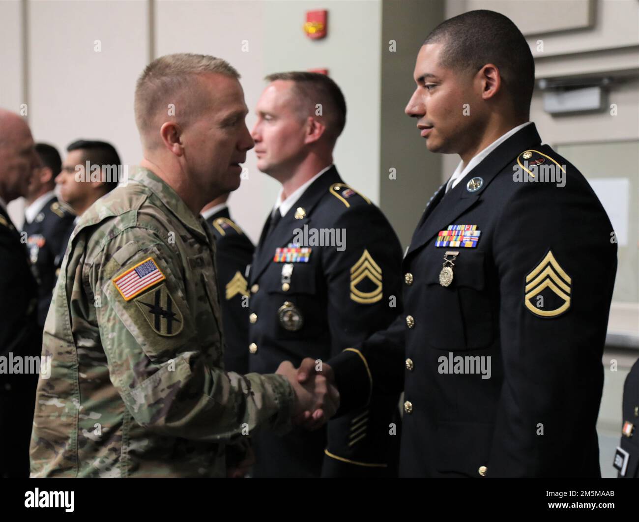 USA Army Major General Tom Carden, der Adjutant General von Georgia, überreicht eine Münze an Staff Sergeant David Dividu, einen Infanteristen mit der Fort Benning 648. Manöver Enhancement Brigade, Georgia Army National Guard, am 24. März 2022 im Clay National Guard Center in Marietta, Georgia. Dividu war einer von 15 Georgia Guardsmen, die im 2022. Georgia Army National Guard State Best Warrior and Noncommissioned Officer Competition teilnahmen. Stockfoto