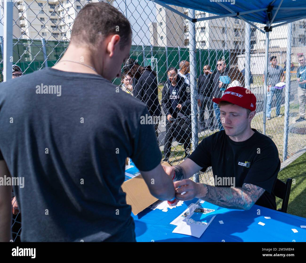 220325-N-RC359-1047 YOKOSUKA, Japan (25. März 2022) Aviation Electricians Mate 2. Class Jason Deaton, aus Asheville, North Carolina, verteilt Getränkekarten an Seeleute beim Picknick der USS Ronald Reagan-Kommandozentrale am Purdy Field Onboard Commander, Fleet Activities Yokosuka. Ronald Reagan, das Flaggschiff der Carrier Strike Group 5, stellt eine kampfbereite Truppe bereit, die die Vereinigten Staaten schützt und verteidigt und Bündnisse, Partnerschaften und kollektive maritime Interessen in der Region Indo-Pazifik unterstützt. Stockfoto