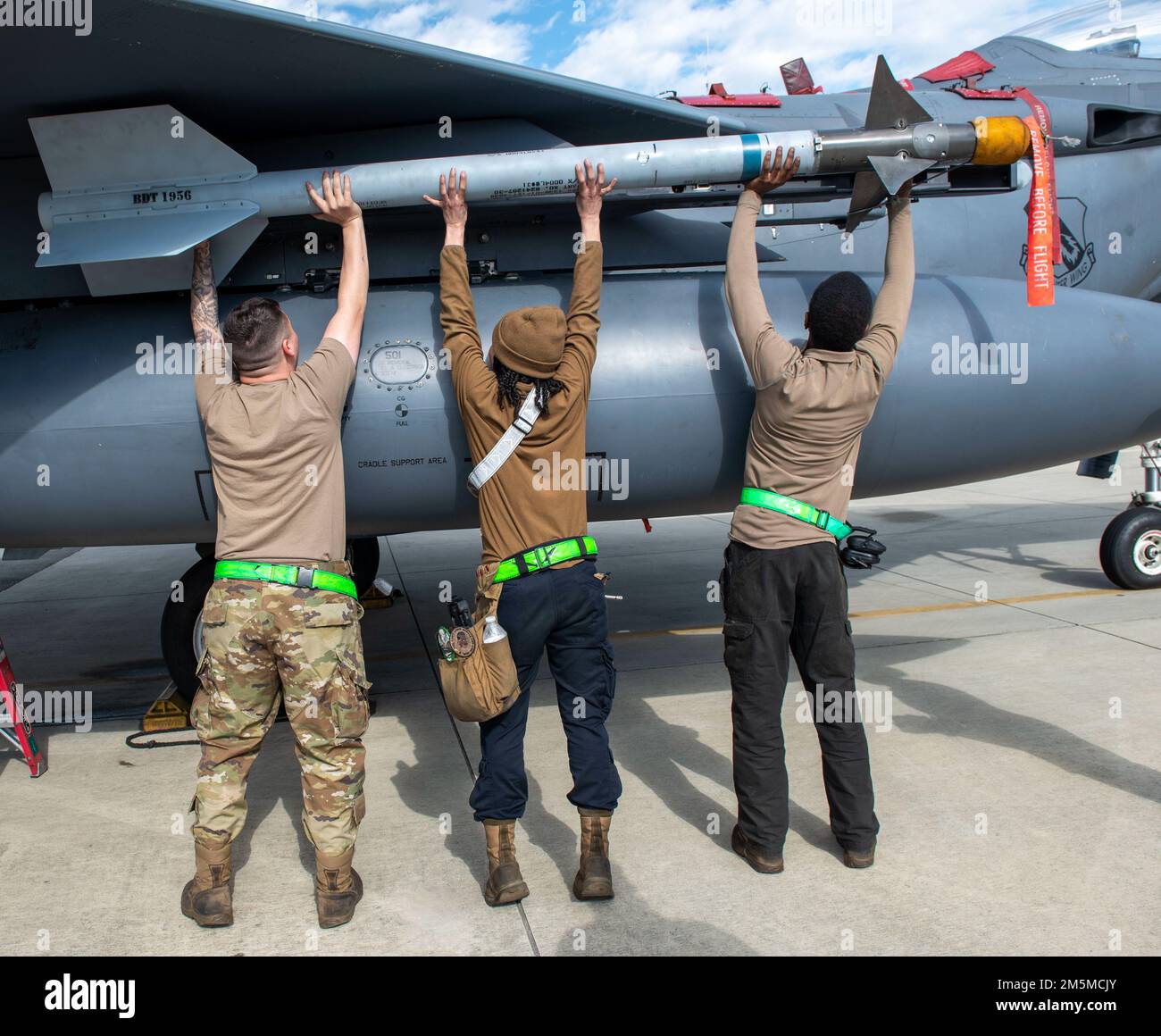 Waffen laden Crew Airmen, die dem 335. Fighter Generation Squadron zugeteilt sind, befestigen eine inerte geführte Bombeneinheit 38 an einem F-15E Strike Eagle während eines jährlichen Load Crew Wettbewerbs am Seymour Johnson Air Force Base, North Carolina, 25. März 2022. Ziel des Wettbewerbs ist es, Flugzeuge zu motivieren und zu Schulen, Kampfflugzeuge für Einsätze und reale Einsätze bereitzustellen. Stockfoto