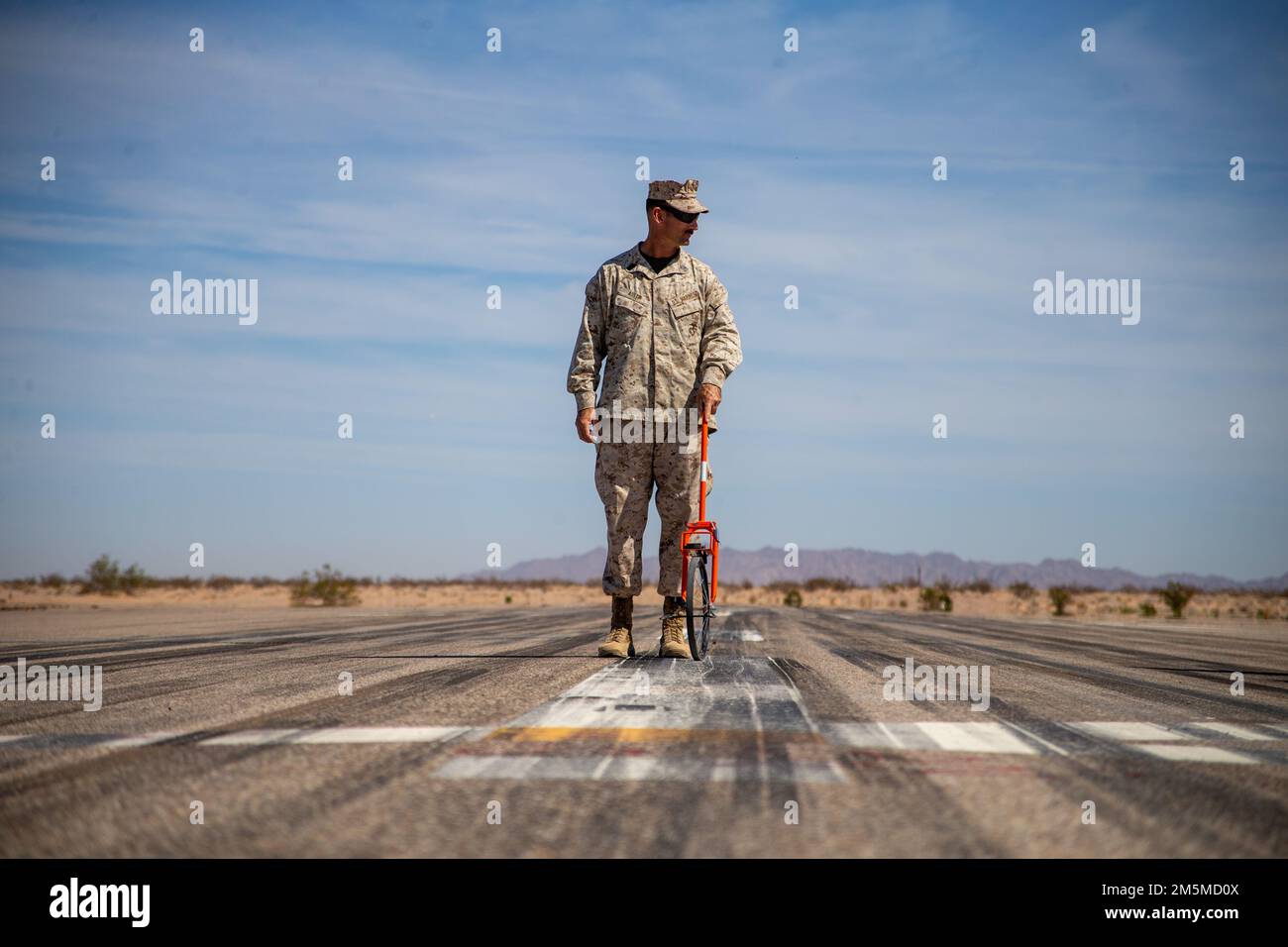 USA Marinekorps Master Sgt. Christopher Austin, ein Logistik- und Mobilitätsleiter aus Fort Walton Beach, Florida, der der Luftfahrt-Bodenunterstützung, dem Marinewaffen- und Taktikschwadron One (MAWTS-1) zugeteilt ist, misst simulierte Spalls auf einer Landebahn und führt dabei eine Mission zur grundlegenden Wiederherstellung nach einem Angriff (Basic Recovery After Attack, BRAAT) durch. Während des Waffen- und Taktiklehrers (WTI) Kurs 2-22, am Hilfsflugplatz II, nahe Yuma, Arizona, 25. März 2022. WTI ist eine siebenwöchige Schulungsveranstaltung, die von MAWTS-1 veranstaltet wird und standardisierte, taktische Schulungen und Zertifizierungen von Kursleiterqualifikationen bietet Stockfoto