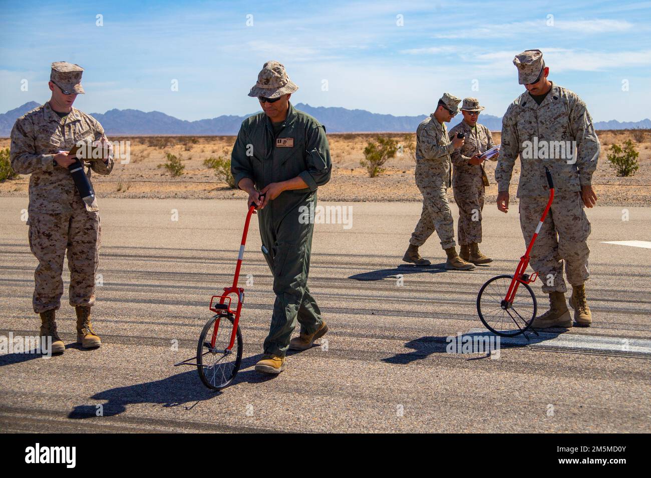 USA Marines mit Luftfahrt-Bodenunterstützung, Marine Aviation Weapons and Tactics Squadron One (MAWTS-1) messen simulierte Spalls auf der Landebahn, während sie eine Basic Recovery After Attack Mission durchführen, um notwendige Reparaturen für einen fiktiv beschädigten Flugplatz zu bestimmen, während des Waffen- und Taktik-Lehrkurses 2-22, auf Hilfsflugplatz II, nahe Yuma, Arizona, 25. März 2022. WTI ist eine siebenwöchige Schulungsveranstaltung, die von MAWTS-1 veranstaltet wird und standardisierte taktische Schulungen und Zertifizierungen von Ausbildungslehrern für Einheiten zur Unterstützung der Ausbildung und Bereitschaft in der Seefahrt sowie von Georgios bietet Stockfoto