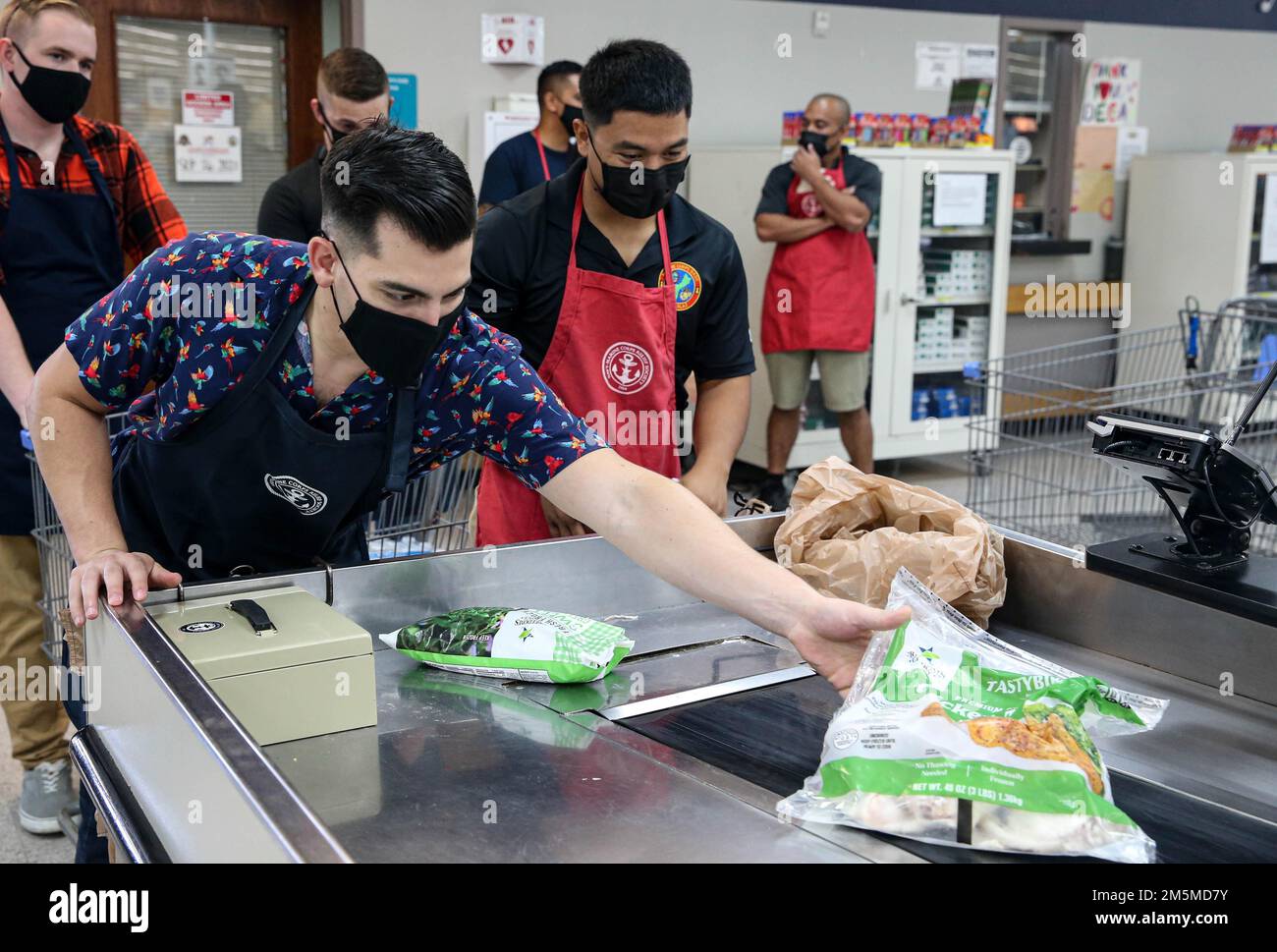 USA Captain Joshua Oblea, Kommunikationsoffizier des Marinekorps-Basislagers Blaz, links, ehrenamtlich bei CPL Donald Pangelinan, Ausbildung eines nicht kommissionierten Offiziers für das Marinekorps-Basislager Blaz, rechts, während einer Veranstaltung der Navy-Marine-Corps Relief Society (NMCRS) im Basiskommissar auf der Marinebasis Guam, 25. März 2022. Die NMCRS ist eine gemeinnützige Organisation, die aktive dienstliche Seeleute und Marines bei Krisen unterstützt, Notfallreisen plant und bezahlt und die Betreuung ihrer Familien in Zeiten der Not bietet. Stockfoto