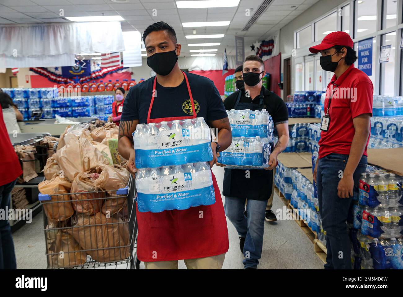 USA Navy Chief Petty Officer Jonmac Diaz, Freiwilligenkoordinator der Guam Regional Navy-Marine Corps Relief Society (NMCRS), unterstützt Marines aus dem Marinekorps-Basislager Blaz bei einer Freiwilligenveranstaltung, die die Organisation am 25. März 2022 im Militärkommissar auf der Marinebasis Guam veranstaltete. Die NMCRS ist eine gemeinnützige Organisation, die aktive dienstliche Seeleute und Marines bei Krisen unterstützt, Notfallreisen plant und bezahlt und die Betreuung ihrer Familien in Zeiten der Not bietet. Stockfoto