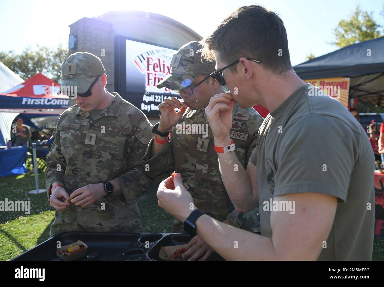 USA Air Force 2. LTS. Hunter Cantrell, Edward Garcia und Andrew Bemis, 333. Studenten der Trainingsschwadron, probieren gekochte Krebse und Beilagen beim jährlichen Crawfish Cook-Off 10. im Bay Breeze Event Center auf dem Luftwaffenstützpunkt Keesler, Mississippi, 25. März 2022. Mehr als 20 Teams nahmen an der Veranstaltung Teil, und mehr als 1.500 kg Langusten wurden verteilt. Stockfoto