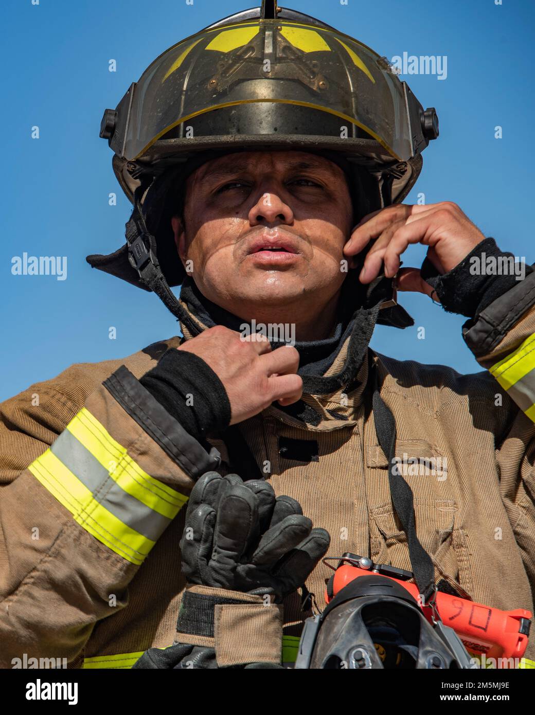 Ein örtlicher Feuerwehrmann aus dem Feuerbezirk Drexel Heights beteiligt sich an einem simulierten Brand in Wohngebäuden auf dem Trainingsgelände des Luftwaffenstützpunkts Davis-Monthan, Arizona, 25. März 2022. Die Beziehung zwischen DM und nahegelegenen Feuerwehrstationen hat sich als positiv erwiesen, was letztlich die Interoperabilität in der Tucson-Community der Ersthelfer stärkt. Stockfoto