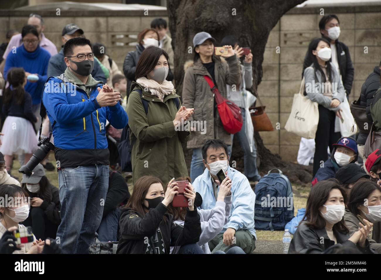 Mitglieder des Luftwaffenstützpunkts Yokota und der japanischen Gemeinde jubeln die Pacific Air Forces Band an, während sie beim Sakura Spring Festival am 26. März 2022 auf dem Luftwaffenstützpunkt Yokota, Japan auftreten. Das Sakura Festival ist eine bilaterale Veranstaltung, die darauf abzielt, die Beziehungen zwischen den USA und Japan zu stärken. Etwa 6.000 externe Community-Mitglieder konnten während der Veranstaltung Kirschblüten sehen und Straßenkünstler und Live-Musik neben der Basis-Community genießen. Stockfoto