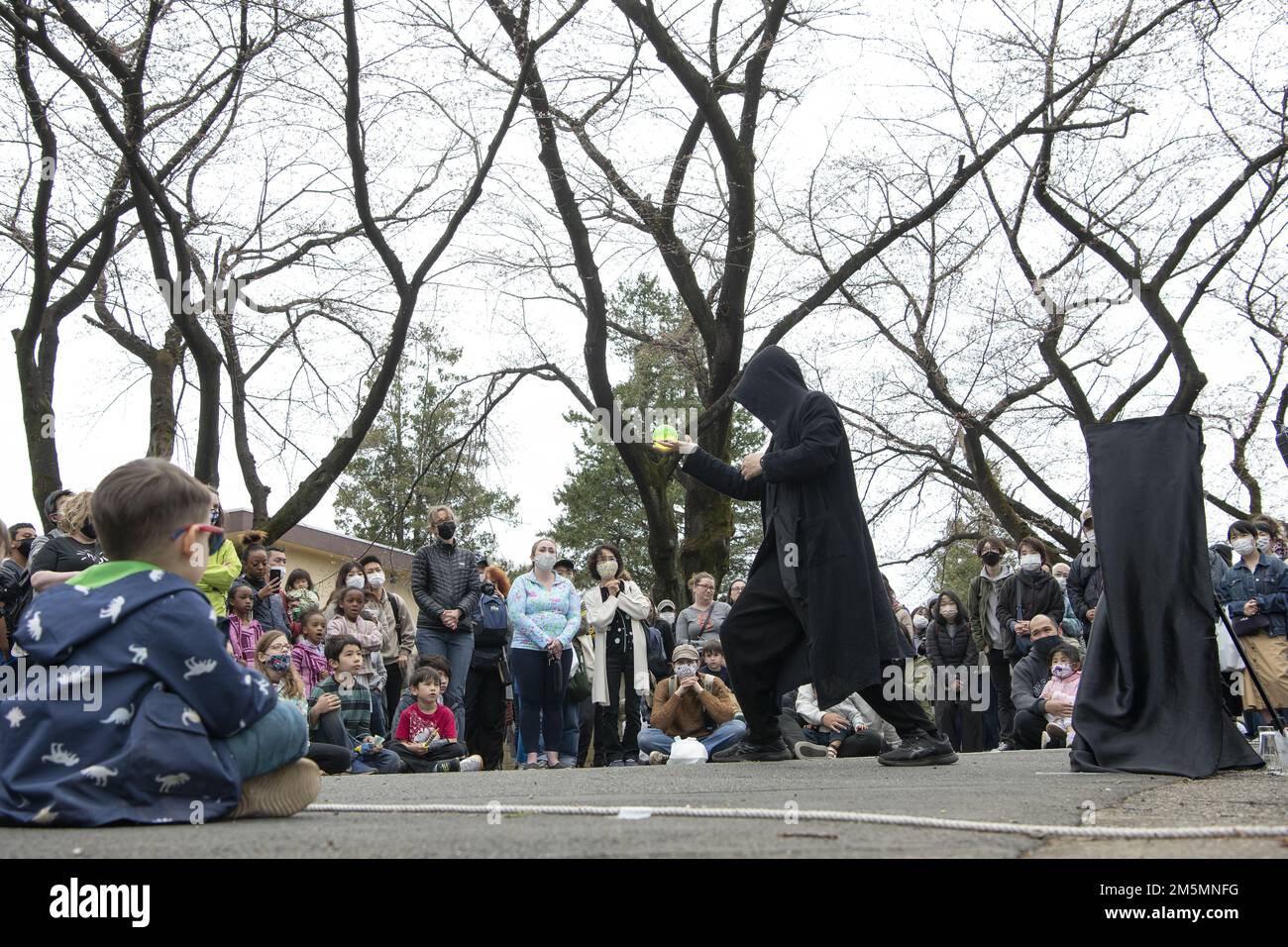 Mitglieder der japanischen Gemeinde und des Luftwaffenstützpunkts Yokota sehen eine Zaubershow während des Sakura Spring Festivals am 26. März 2022 auf dem Luftwaffenstützpunkt Yokota, Japan. Das Sakura Festival ist eine bilaterale Veranstaltung, die darauf abzielt, die Beziehungen zwischen den USA und Japan zu stärken. Etwa 6.000 externe Community-Mitglieder konnten während der Veranstaltung Kirschblüten sehen und Straßenkünstler und Live-Musik neben der Basis-Community genießen. Stockfoto