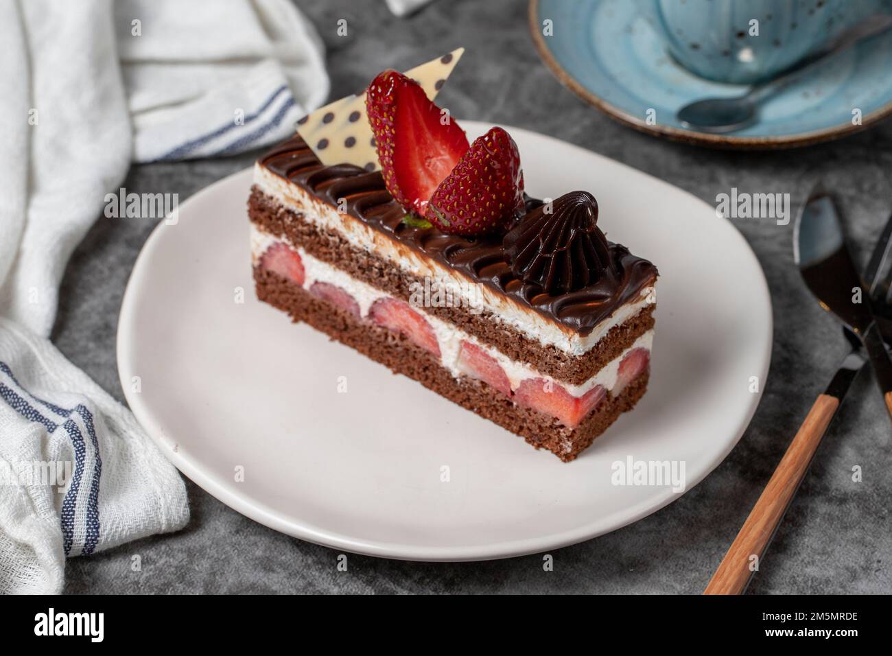 Erdbeeren- und Schokoladenkuchen auf dunklem Hintergrund. Ein Stück Schokoladenkuchen. Backwaren. Schließen Stockfoto