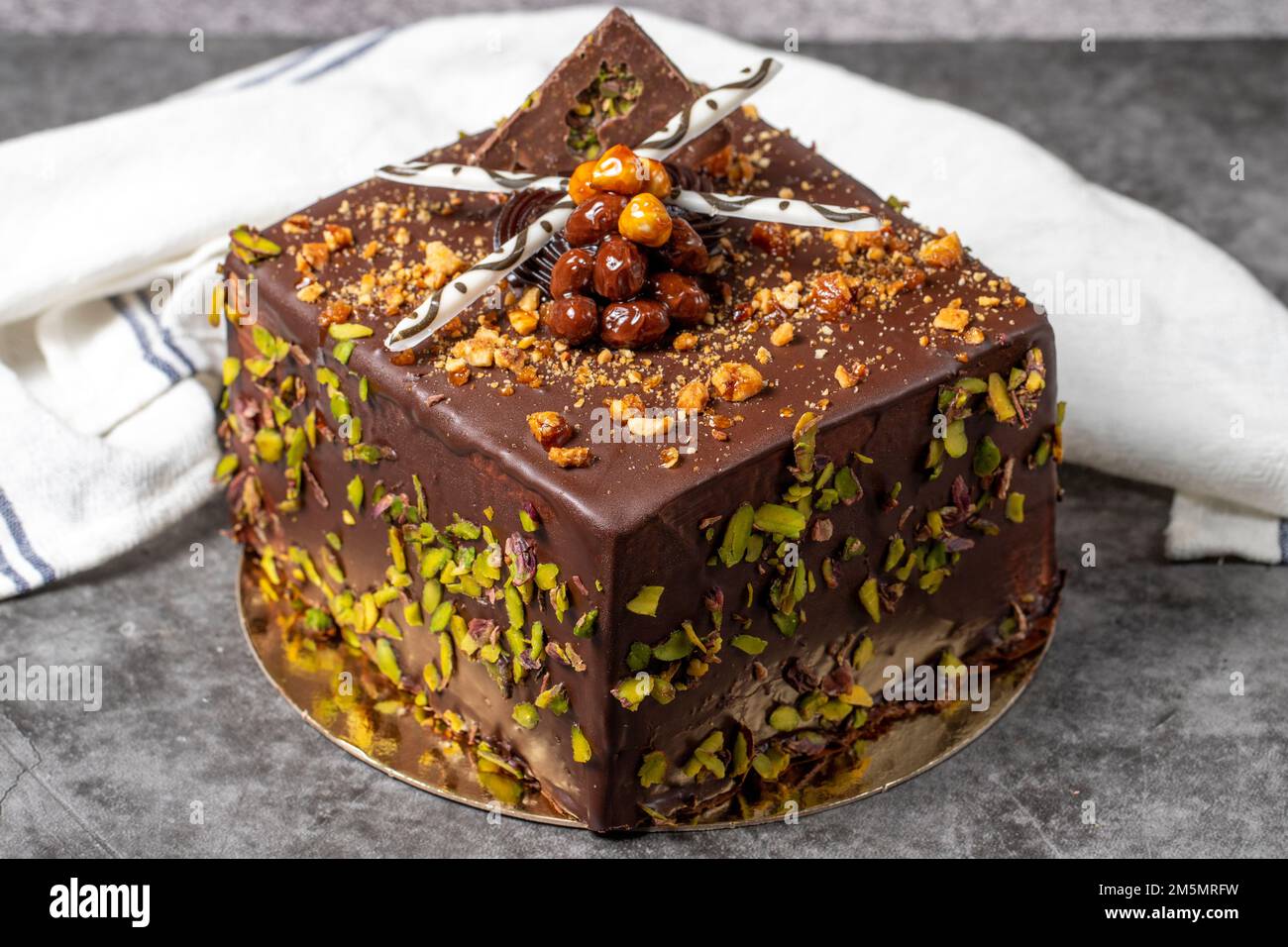 Schokolade und Pistazienkuchen auf dunklem Hintergrund. Geburtstagskuchen oder Festtagskuchen. Schließen Stockfoto