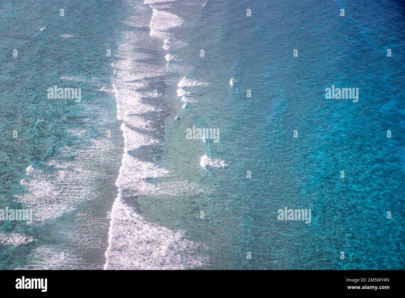 Blick aus der Luft auf das Meer, Blick von oben auf die atemberaubende Natur, den Ozean Hintergrund. Leuchtend blaue Wasserfarben, Lagunenstrand mit Wellen, die an sonnigen Tagen plätschern. Fliegende Drohne Stockfoto