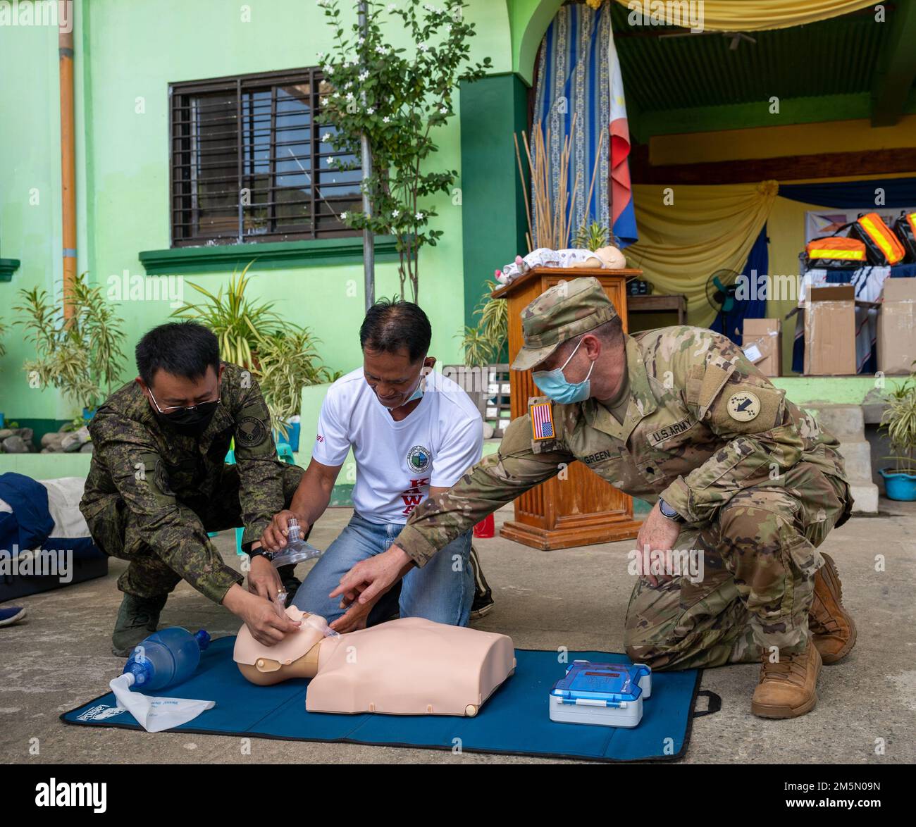 Philippinischer Marineministerium Derek Buena Tino, Leiter des Pflegedienstes, mit dem Basa Air Base Hospital (links) und den USA Jordan Green, Kampfsanitäter mit den USA Army Pacific (rechts), unterstützen Sie einen lokalen Ersthelfer bei der richtigen Lebensrettungstechnik während einer Outreach- und Trainingsereignis in Taggut Sur, Claveria, Philippinen, 28. März 2022 während der Übung Balikatan 22. Balikatan, Tagalog für „Schulter-an-Schulter“, ist eine langjährige bilaterale Übung zwischen den Philippinen und den Vereinigten Staaten, die die tief verwurzelte Partnerschaft zwischen beiden Ländern hervorhebt. Balikatan 22 fällt mit dem 75. Jubiläum zusammen Stockfoto