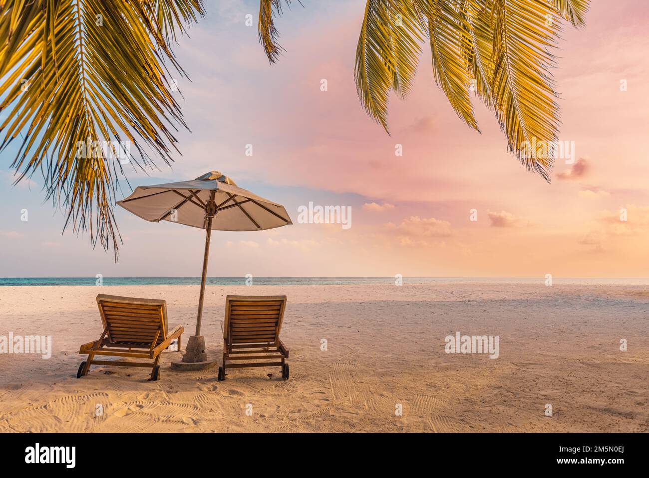 Wunderschöne tropische Insel, paar Stühle Sonnenschirm unter Palmenblättern, Paradies Meer Sand Himmel. Sommer Reise Landschaft erstaunliche Urlaub Strand Stockfoto