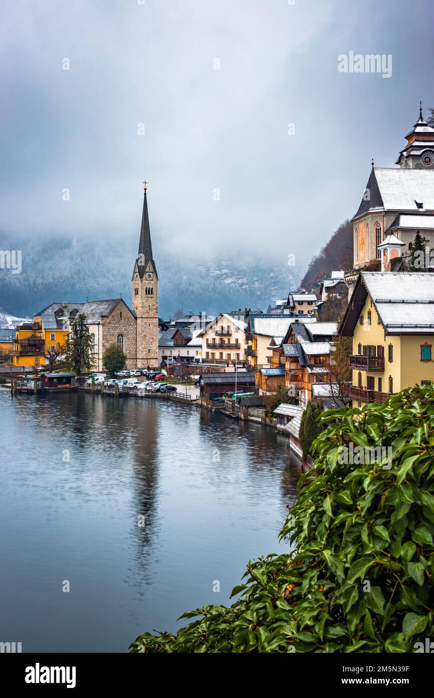 Hallstatt, Österreich - berühmte Aussicht auf den weltberühmten Hallstatt, die zum UNESCO-Weltkulturerbe gehörende Stadt am See mit der Lutherischen Hallstatt-Kirche an einem kalten nebligen Tag Stockfoto