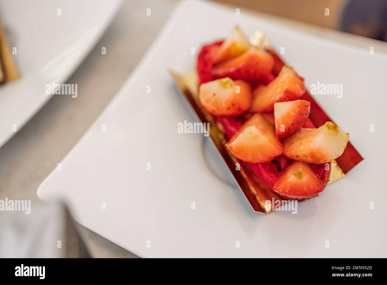 Geschnittene Erdbeeren auf weißem Hintergrund, selektiver Fokus, Nahaufnahme in elegantem Luxusrestaurant. Erdbeerkuchen Stockfoto