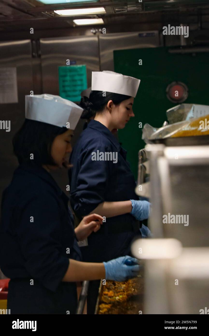 220329-N-HK187-1005 ATLANTISCHER OZEAN (29. März 2022) – Electrician’s Mate Fireman Apprentice Robins, Right, and Culinary Specialist Seaman Recruit Zhenyan Shen, zugewiesen zum Arleigh Burke-Class Guided-Missile Destroyer USS the Sullivans (DDG 68), Mittagessen am „Taco Tuesday“, März 29. Die Sullivans werden in das europäische Operationstheater entsandt und nehmen an einer Reihe von maritimen Aktivitäten zur Unterstützung der USA Teil Sechste Flotte und NATO-Alliierten. Stockfoto