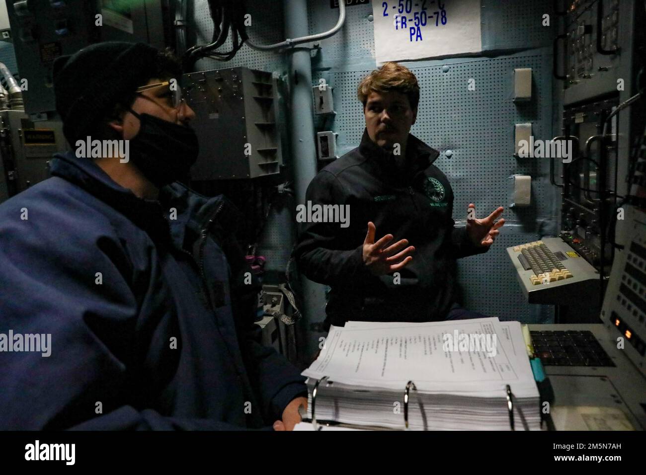 220329-N-HK187-1002 ATLANTISCHER OZEAN (29. März 2022) – Sonar Technician (Surface) 2. Class Calvin Day, Right, zugewiesen an den Arleigh Burke-Class Guided-Missile Destroyer USS The Sullivans (DDG 68), gibt Ausbildung für einen neuen Matrosen, März 29. Die Sullivans werden in das europäische Operationstheater entsandt und nehmen an einer Reihe von maritimen Aktivitäten zur Unterstützung der USA Teil Sechste Flotte und NATO-Alliierten. Stockfoto