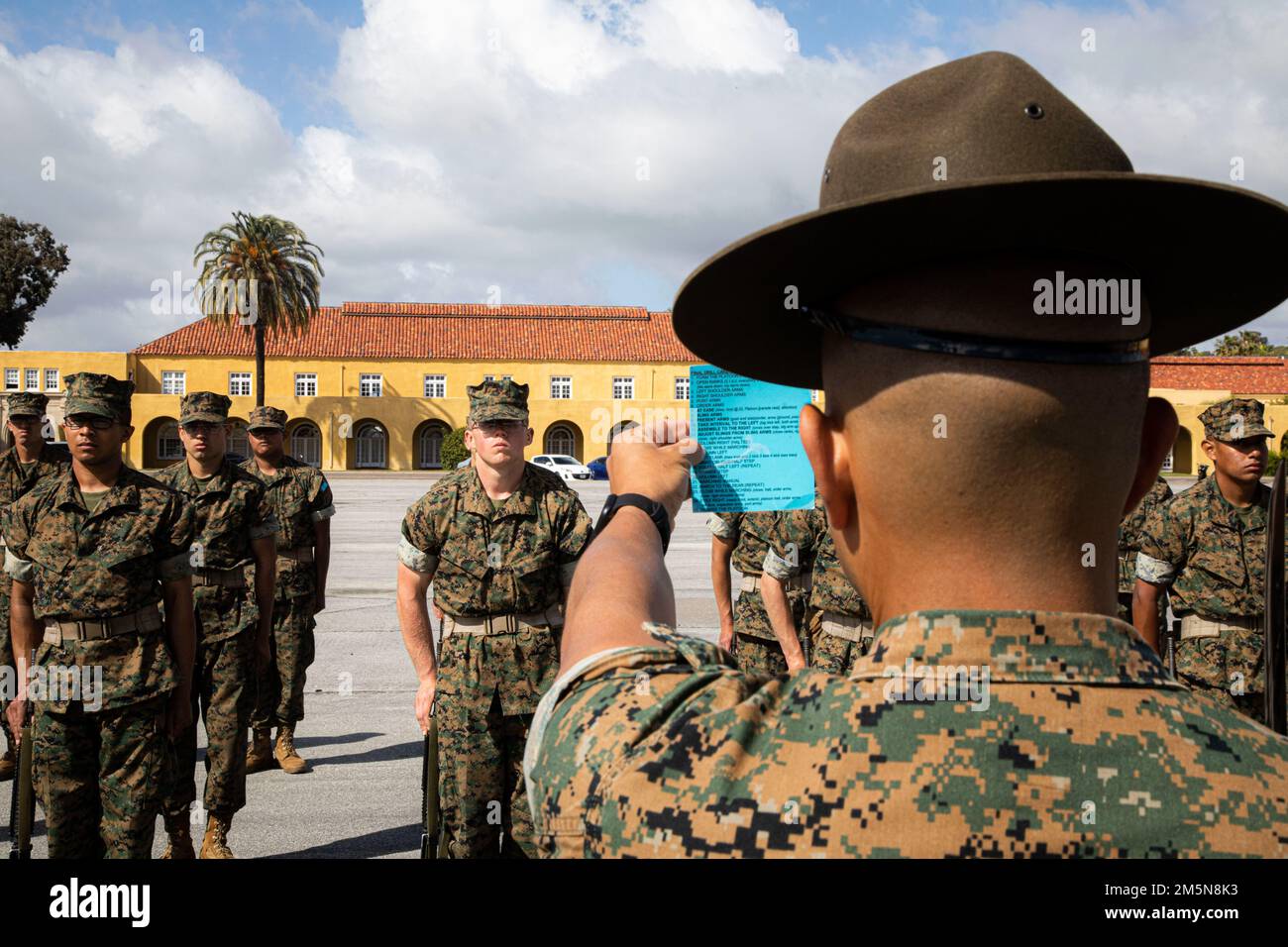USA Marinekorps Staff Sgt. Rene Torres, leitender Ausbilder bei der Kilo Company, 3. Recruit Training Bataillon, liest eine Trainingskarte vor, bevor er das nächste Kommando während einer Übung zum Marinekorps Recruit Depot San Diego rezitiert, 29. März 2022. Rekrutiert während des Trainings gelernte und ausgeführte Bohrbewegungen als Zug, um Individualismus zu beseitigen und Disziplin zu schaffen. Stockfoto