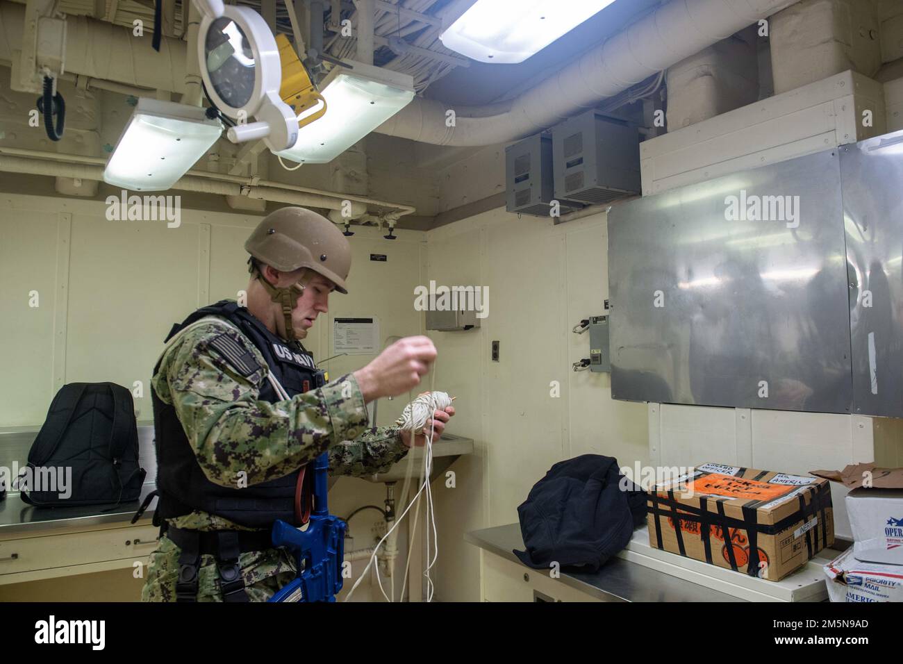 SASEBO, Japan (29. März 2022) Cryptologic Technician (Technical) 2. Klasse James Slade, aus Odessa, Texas, dem nach vorn eingesetzten Amphibienschiff USS America (LHA 6) zugewiesen, verwendet Seil, um einen Weg zur Beseitigung von Sprengkörpern zu einem simulierten verdächtigen Paket während einer Übung in der Hafensicherheit zu errichten. Amerika, das führende Schiff der America Amphibious Ready Group, ist im Zuständigkeitsbereich der US-amerikanischen 7.-Flotte tätig, um die Interoperabilität mit Verbündeten und Partnern zu verbessern und als bereitstehende Eingreiftruppe zur Verteidigung von Frieden und Stabilität in der Region Indo-Pazifik zu dienen. Stockfoto