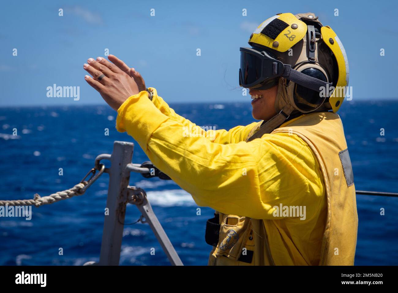 220330-N-TT059-2075 SÜDCHINESISCHE SEE (30. März 2022) Boatswain's Mate 2. Elisa Sierra gibt Handsignale während vertikaler Wiederauffüllungsoperationen (VERTREP) an Bord der Guided-Missile Destroyer USS Momsen (DDG 92). Momsen ist dem Befehlshaber der Task Force 71/Destroyer Squadron (DESRON) 15, dem größten vorwärtsstationierten DESRON der Marine und der Hauptstreitkräfte der US-7.-Flotte zugewiesen und unterstützt derzeit ein freies und offenes Indo-Pacific. Stockfoto