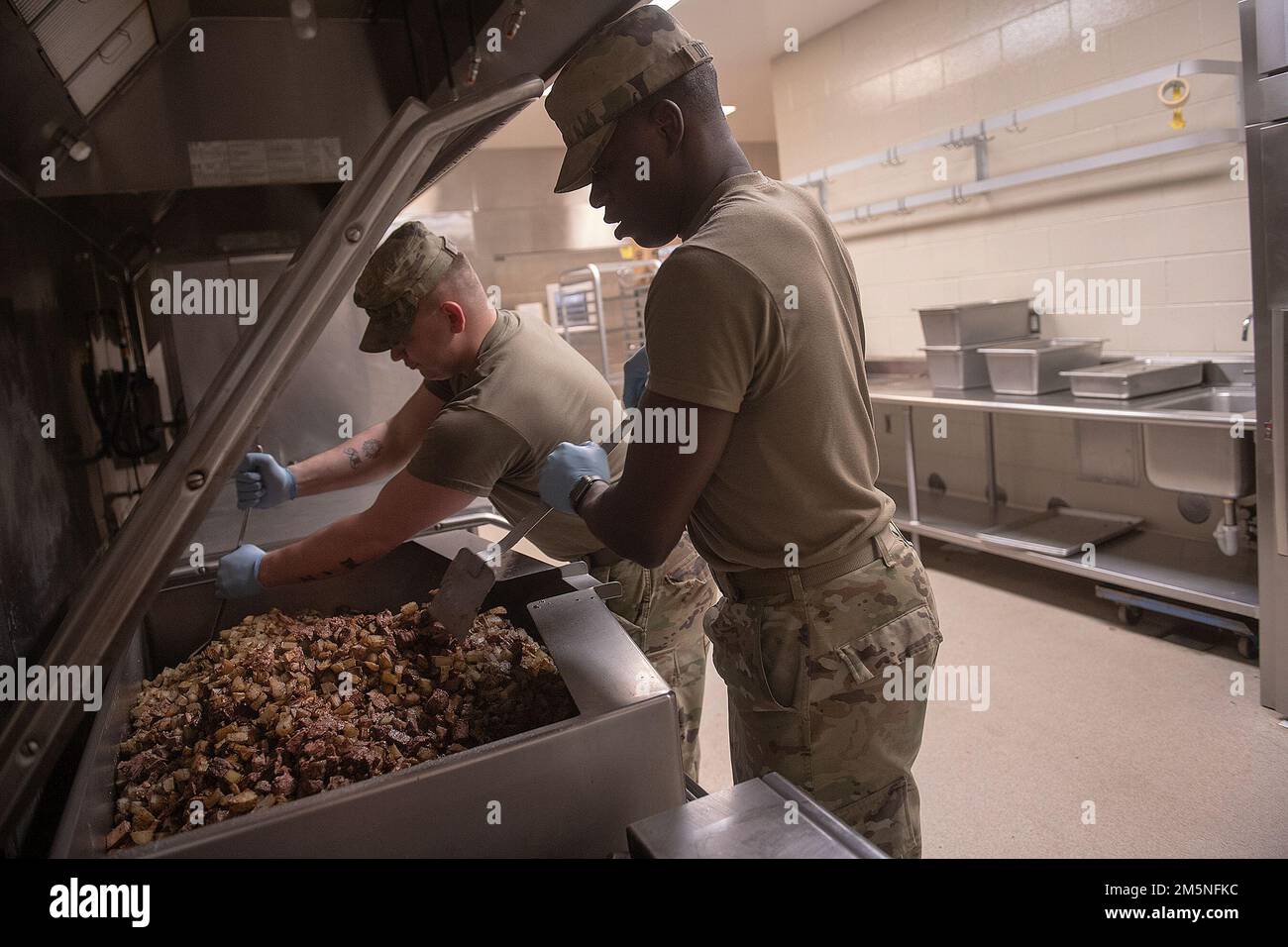 Idaho Army National Guard SPC. Jonah Dittenber (rechts) und PFC. Ethan Mitchell beginnen mit dem Rühren der Töpfe. Napoleon Bonaparte heißt es: "Eine Armee marschiert auf dem Bauch." Das Sprichwort zeigt, wie wichtig es ist, dass Soldaten im Feld nur dann effektiv sein können, wenn sie gut gefüttert sind. In den letzten Tagen des März war das 2-116.-Militärbataillon der Nationalgarde Idaho im Einsatz im Ausbildungszentrum für Orchard-Kampfhandlungen, um einen bevorstehenden Einsatz zur Unterstützung der Operation Spartan Shield vorzubereiten. Die Schulung war rigoros und vielfältig. Während jedes Unternehmen die ausgefüllt hat Stockfoto