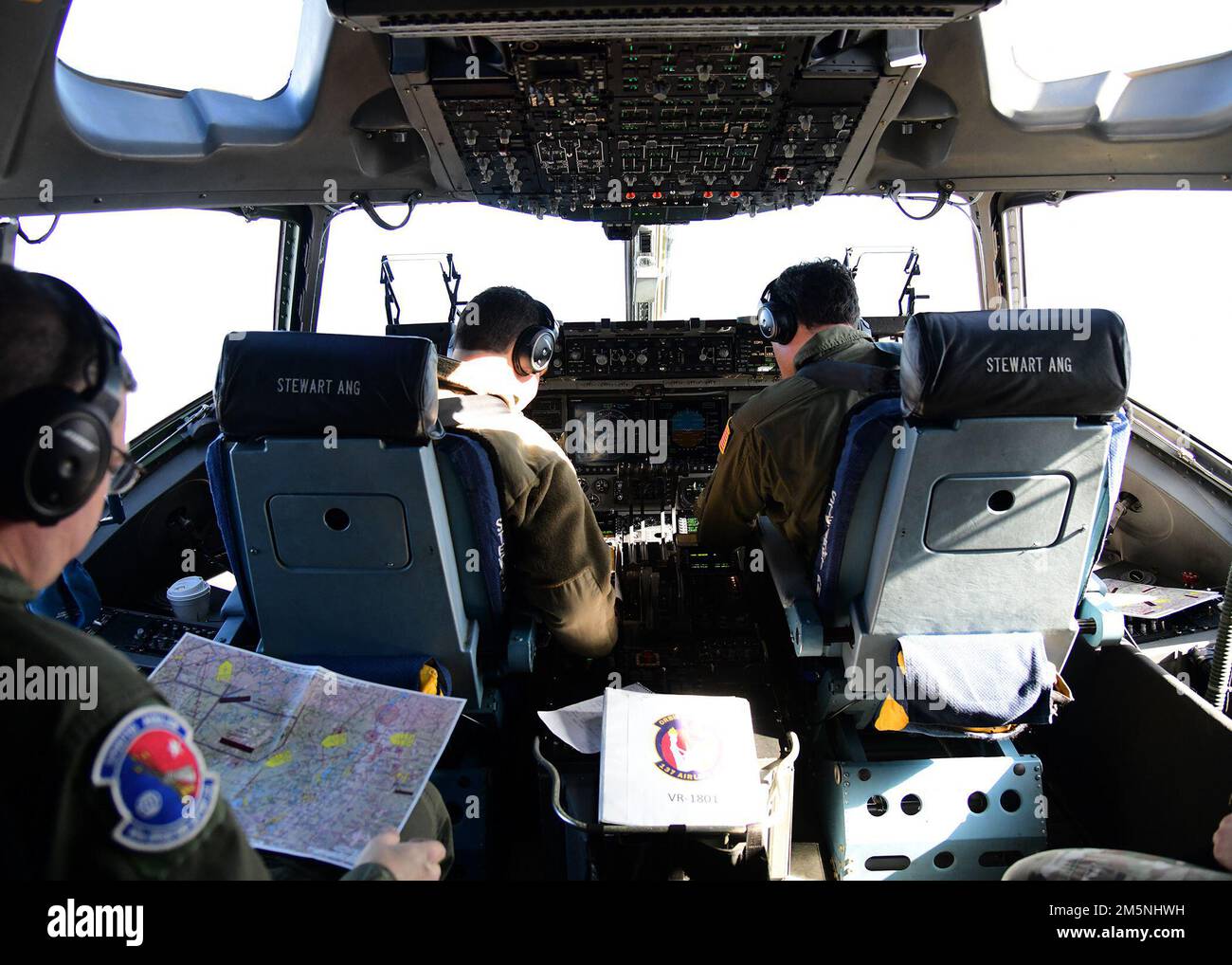 USA Air Force Tech. Sgt. John Neumann, ein Ladermeister, der dem 105. Luftschleusenflügel zugeteilt ist, alarmiert C-17 Globemaster-Piloten in den USA Air Force Captain James Pyjas und USA Oberstleutnant Charles Sendral der Luftwaffe, simulierte feindliche Bedrohungszonen während einer Übung über Syracuse, New York, 24. Februar 2022. Die Übung wurde in Abstimmung mit dem 174. Attack Wing durchgeführt, um unterschiedliche Ressourcen in der New York Air National Guard zu integrieren. Stockfoto