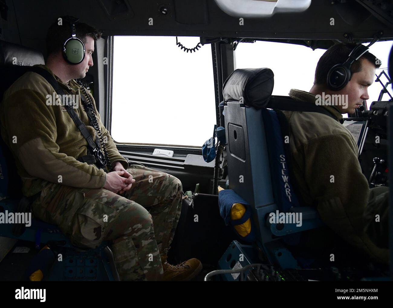 US Air Force Master Sgt. Bryan McCarthy, dem 105. Airlift Wing Intelligence Office zugeteilt, sieht aus wie US Air Force Captain James Pyjas, ein Pilot, der dem 105. Airlift-Flügel zugeteilt ist, fliegt einen C-17 Globemaster während einer Übung über Syracuse, New York, am 24. Februar 2022. Die Übung wurde in Abstimmung mit dem 174. Attack Wing durchgeführt, um unterschiedliche Ressourcen in der New York Air National Guard zu integrieren. Stockfoto