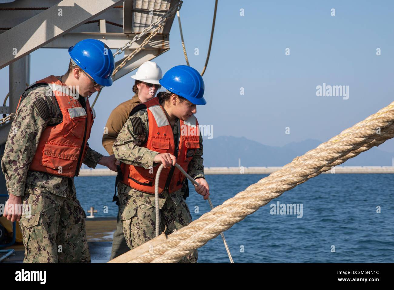 USA Navy Seaman Christian Sucik, Left, und Petty Officer dritter Klasse Nubia Villatoro, beide Enginemen des Marine Corps Air Station Iwakuni's Harbor Operations Department, haben am 25. Februar 2022 in MCAS Iwakuni, Japan, einen Ölboom ausgelöst. Seeleute an den Hafenanlegeschiffen, helfen bei der Entladung der Ausrüstung und halten die Betriebsfähigkeit der Hafenausrüstung aufrecht. Der Tiefwasserhafen von MCAS Iwakuni spielt eine wesentliche Rolle bei der Versorgung der Einheiten der Flugstation mit der erforderlichen Ausrüstung und bei der Unterstützung verschiedener Schiffe, die durch die Region Indo-Pazifik fahren. Stockfoto