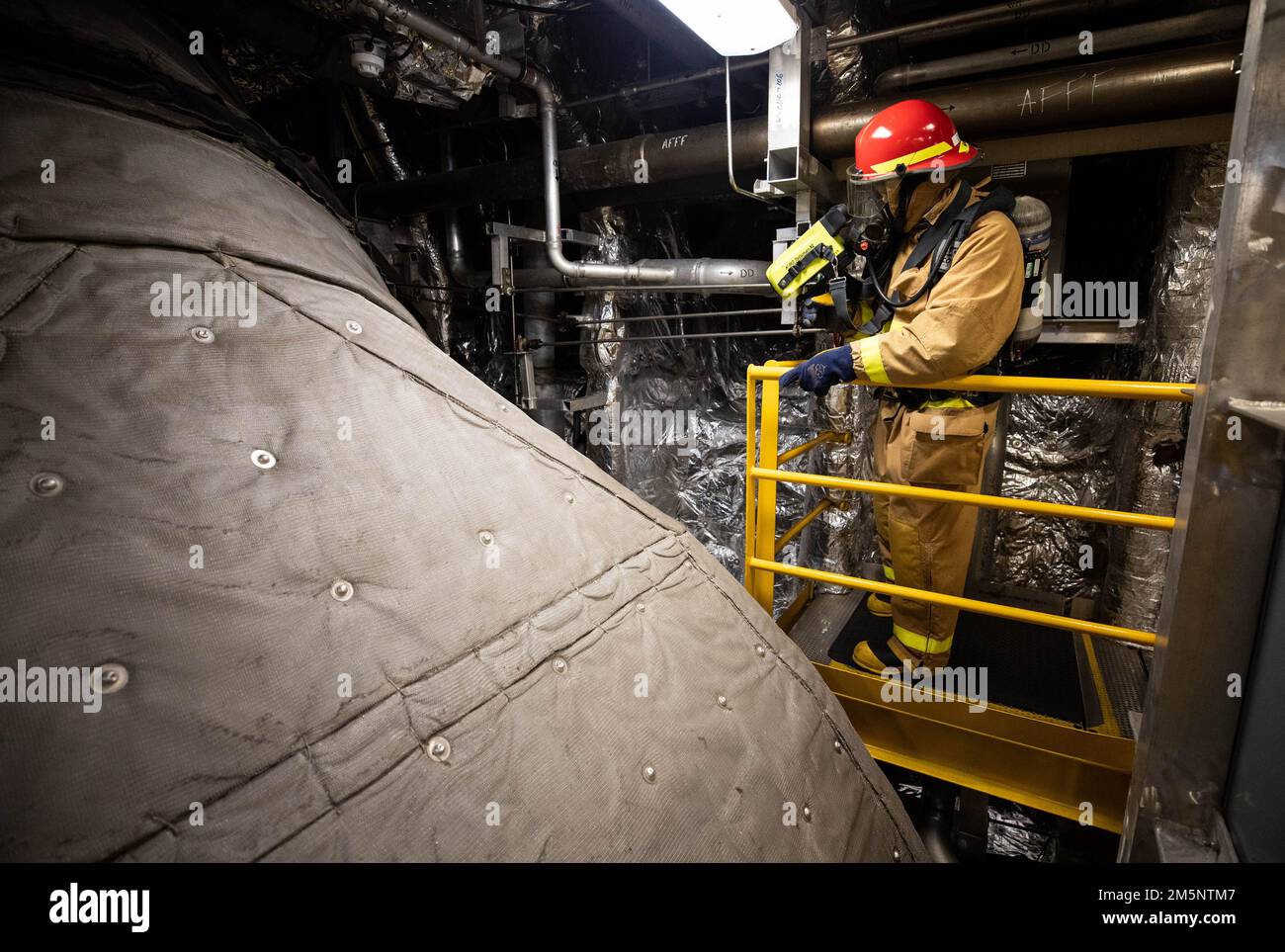 220226-N-LI768-1078 MANILA, Philippinen (26. Februar 2022) – Mineman 1., Klasse Nigel Littleton, aus Colorado Springs, Colorado, verwendet eine Wärmebildkamera, um während der Schadenverhütungsschulung an Bord des Küstenschiffes USS Tulsa (LCS 16) nach Hotspots im Maschinenraum Nummer 1 zu suchen. Tulsa, Teil der Destroyer Squadron (DESRON) 7, befindet sich in einem Rotationseinsatz und ist im US-amerikanischen 7.-Flottengebiet tätig, um die Interoperabilität mit Partnern zu verbessern und als einsatzbereite Einsatztruppe zur Unterstützung einer freien und offenen Region Indo-Pazifik zu dienen. Stockfoto