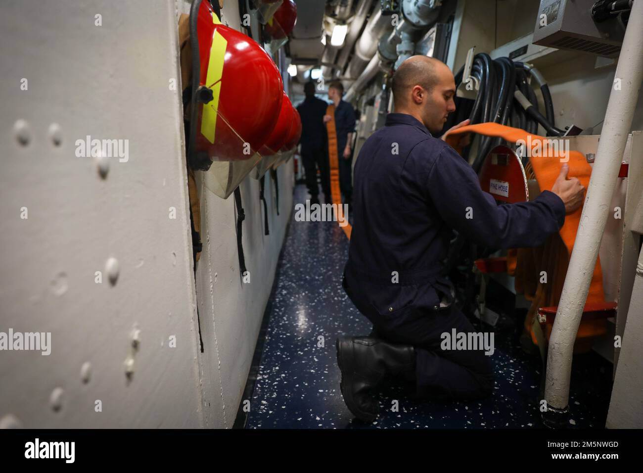 220226-N-EM691-1002 ATLANTISCHER OZEAN (26. Februar 2022) Damage Controlman 3. Klasse Adison Bassili, dem Guided-Missile Destroyer USS The Sullivans (DDG 68) zugeteilt, verstaut einen Feuerwehrschlauch nach einer allgemeinen Quartierübung, Februar 26. Die Sullivans (DDG 68) werden im europäischen Operationssaal eingesetzt und nehmen an einer Reihe von maritimen Aktivitäten zur Unterstützung der USA Teil Sechste Flotte und NATO-Alliierten. Stockfoto