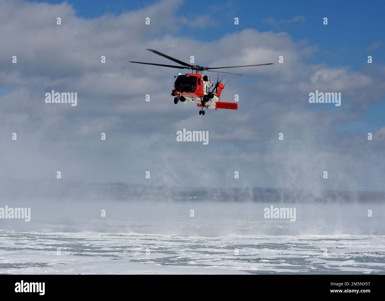Ein MH-60 Jayhawk von der Air Station Traverse City bereitet sich darauf vor, einen Rettungsschwimmer während einer massiven Eisrettungsübung am 26. Februar 2022 in der städtischen Marina von Petoskey auf das Eis zu senken. Die Übung, bei der der Absturz eines Pendlerflugzeugs auf dem gefrorenen Lake Michigan simuliert wurde, brachte mehr als 100 Ersthelfer und Mitglieder der Küstenwache aus dem gesamten Norden von Michigan zusammen. Foto der US-Küstenwache vom Chief Petty Officer John Masson. Stockfoto