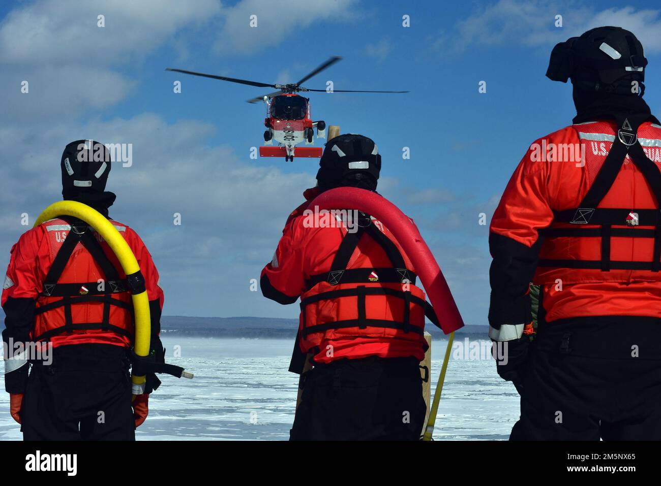 Ein MH-60 Jayhawk von der Air Station Traverse City bereitet sich darauf vor, einen Rettungsschwimmer während einer massiven Eisrettungsübung am 26. Februar 2022 in der städtischen Marina von Petoskey auf das Eis zu senken. Die Übung, bei der der Absturz eines Pendlerflugzeugs auf dem gefrorenen Lake Michigan simuliert wurde, brachte mehr als 100 Ersthelfer und Mitglieder der Küstenwache aus dem gesamten Norden von Michigan zusammen. Foto der US-Küstenwache vom Chief Petty Officer John Masson. Stockfoto