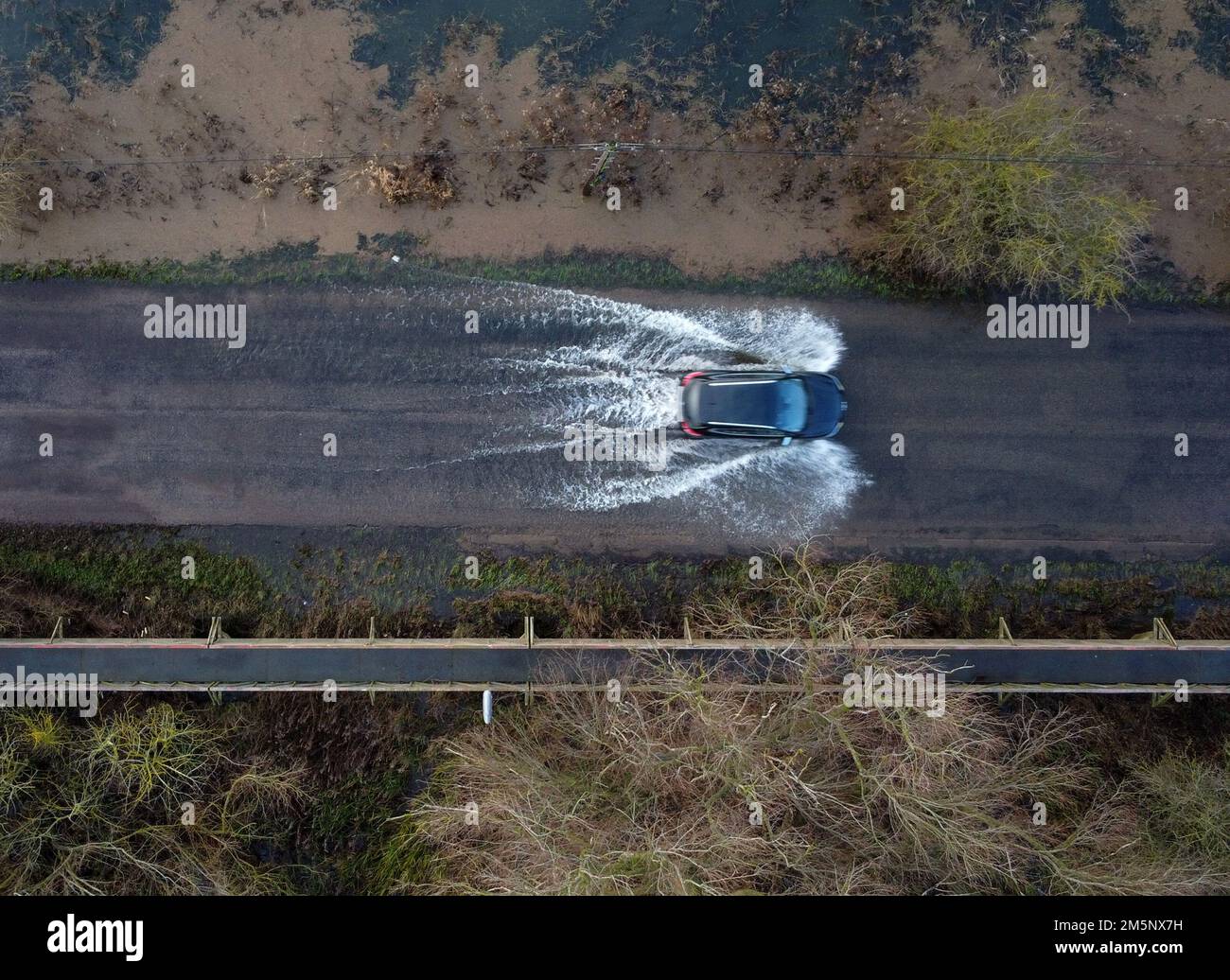 Ein Auto fährt durch Überschwemmungen, da die Niveaus des Flusses Great Ouse bei Sutton, Cambridgeshire, sehr hoch sind nach dem jüngsten starken Regen und Schnee, da die Umweltbehörde Hochwasserwarnungen für viele Teile der Grafschaft ausgegeben hat. Stockfoto