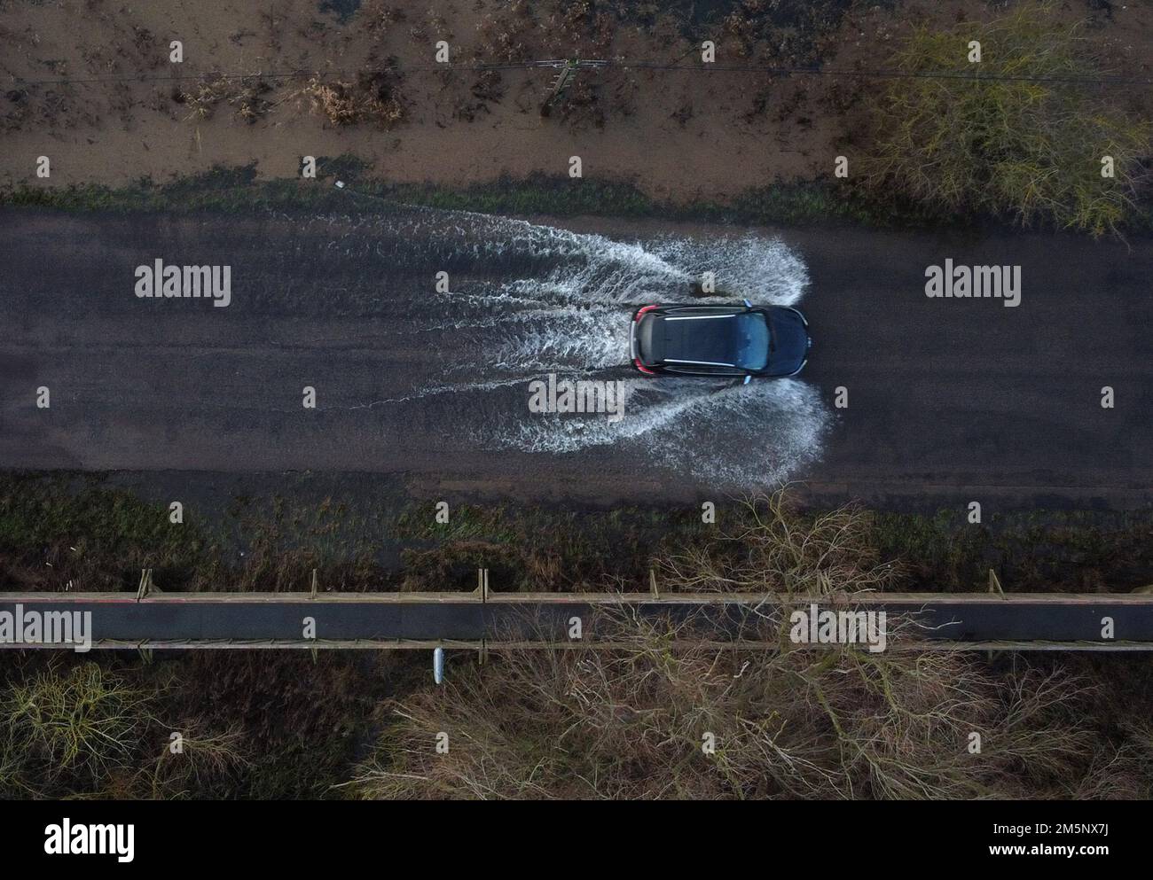 Ein Auto fährt durch Überschwemmungen, da die Niveaus des Flusses Great Ouse bei Sutton, Cambridgeshire, sehr hoch sind nach dem jüngsten starken Regen und Schnee, da die Umweltbehörde Hochwasserwarnungen für viele Teile der Grafschaft ausgegeben hat. Stockfoto