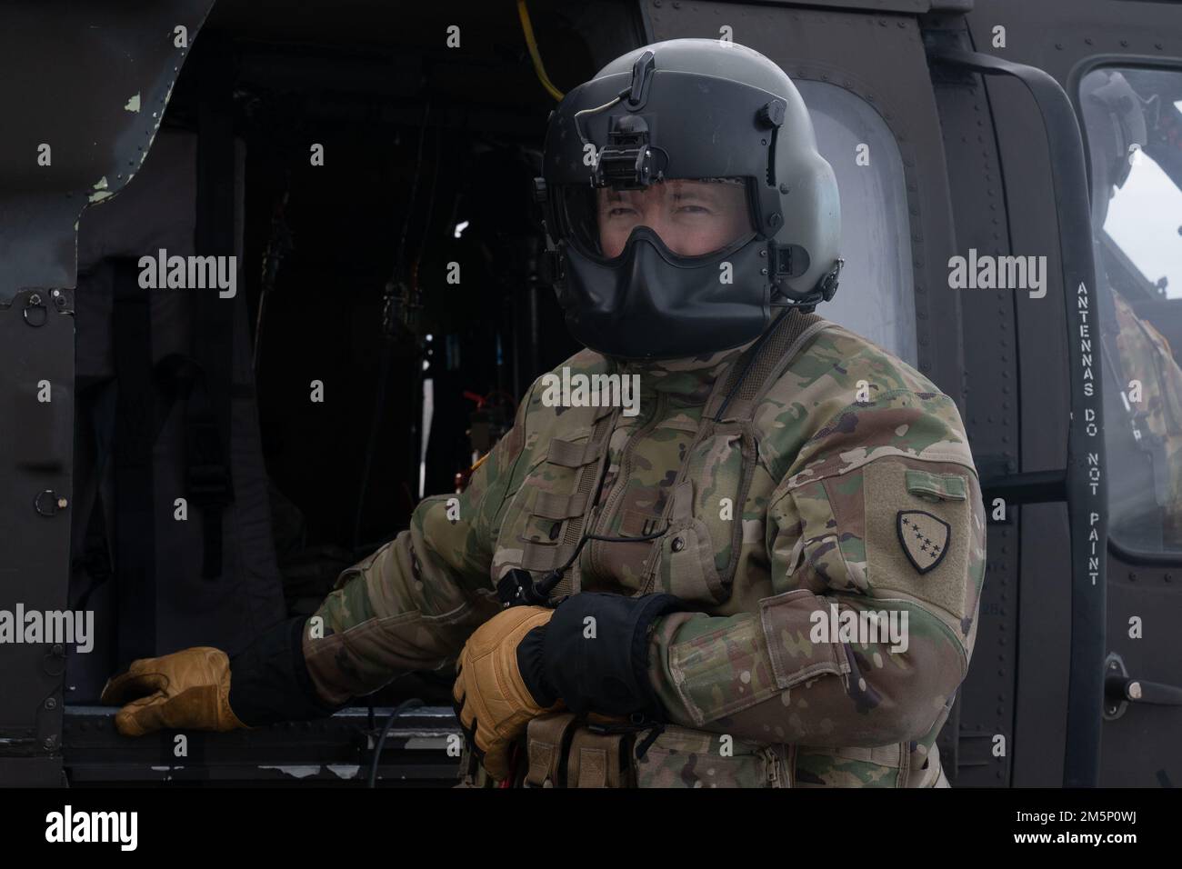 Ein Alaska Army National Guardsman steht vor einer Alaska Army National Guard UH-60L Blackhawk, die beide dem 207. Luftfahrtregiment zugeteilt wurden, während einer gemeinsamen Feldübung in Camp Mad Bull, Joint Base Elmendorf-Richardson, Alaska, 26. Februar 2022. Die gemeinsame Aktion wurde durchgeführt, um die reaktionsschnellen Maßnahmen der USA zu verstärken Air Force- und AKANG-Personal in einer arktischen Umgebung, indem es arktische Verteidigungspositionen errichtet, individuelle Bewegungstechniken, Techniken zum Waffenhandhaben und Fahrzeugtraining bei kaltem Wetter durchführt. Stockfoto