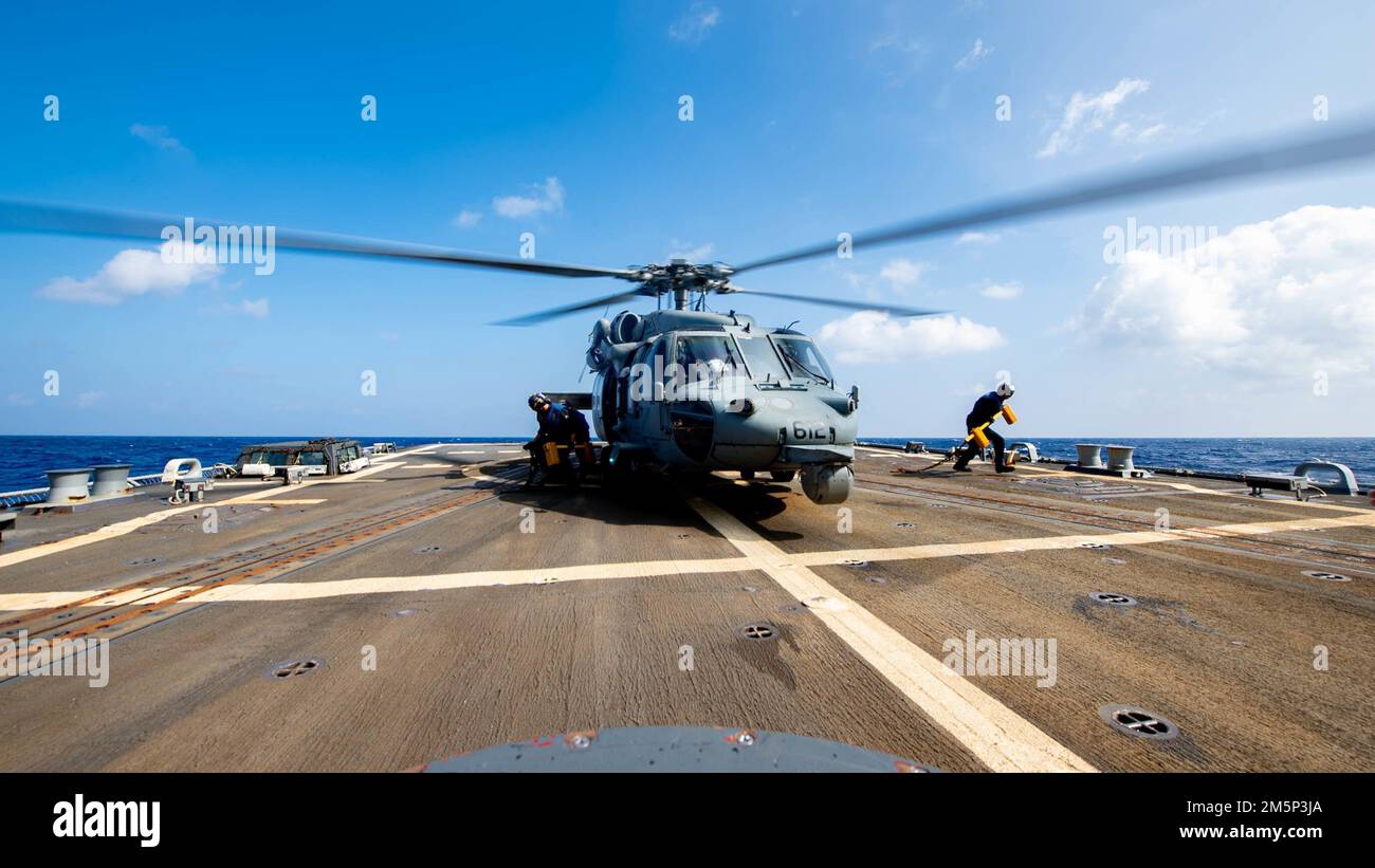 PAZIFIK (27. Februar 2022) Seeleute ziehen Keile und Ketten aus einem MH-60s Sea Hawk Helikopter, der den ‚Chargers‘ des Helicopter Sea Combat Squadron (HSC) 14 zugeteilt ist und vom Flugdeck des Arleigh Burke-Klasse-Guided-Missile Destroyers USS Spruance (DDG 111) startet. Die Abraham Lincoln Strike Group befindet sich in einem geplanten Einsatz im US-7.-Flottenbereich, um die Interoperabilität durch Allianzen und Partnerschaften zu verbessern und gleichzeitig als einsatzbereite Truppe zur Unterstützung einer freien und offenen Region Indo-Pacific zu fungieren. Stockfoto