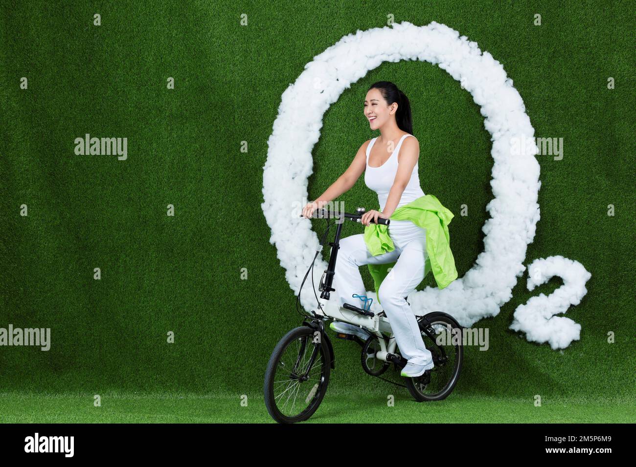 Die graskreativen jungen Frauen fahren Fahrrad Stockfoto
