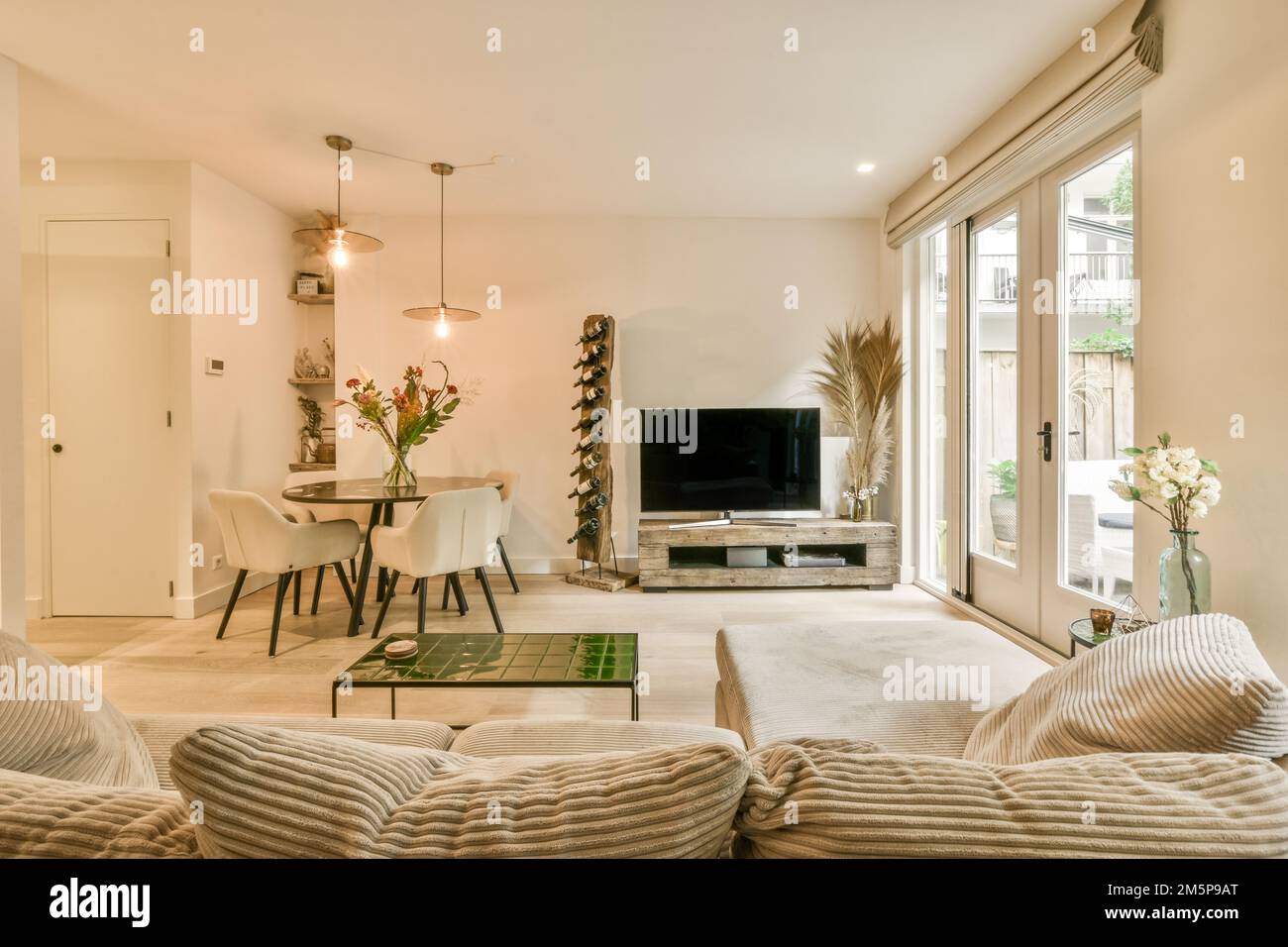 Ein Wohnzimmer mit zwei Sofas und einem Fernseher in der Mitte des Zimmers  ist eine offene Terrasse Stockfotografie - Alamy