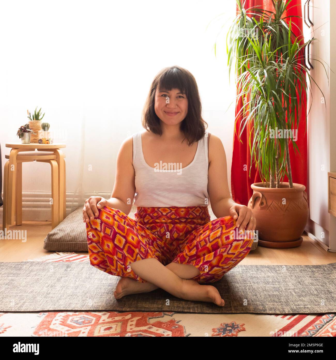 Junge weiße Frau, die zu Hause Yoga praktiziert Stockfoto